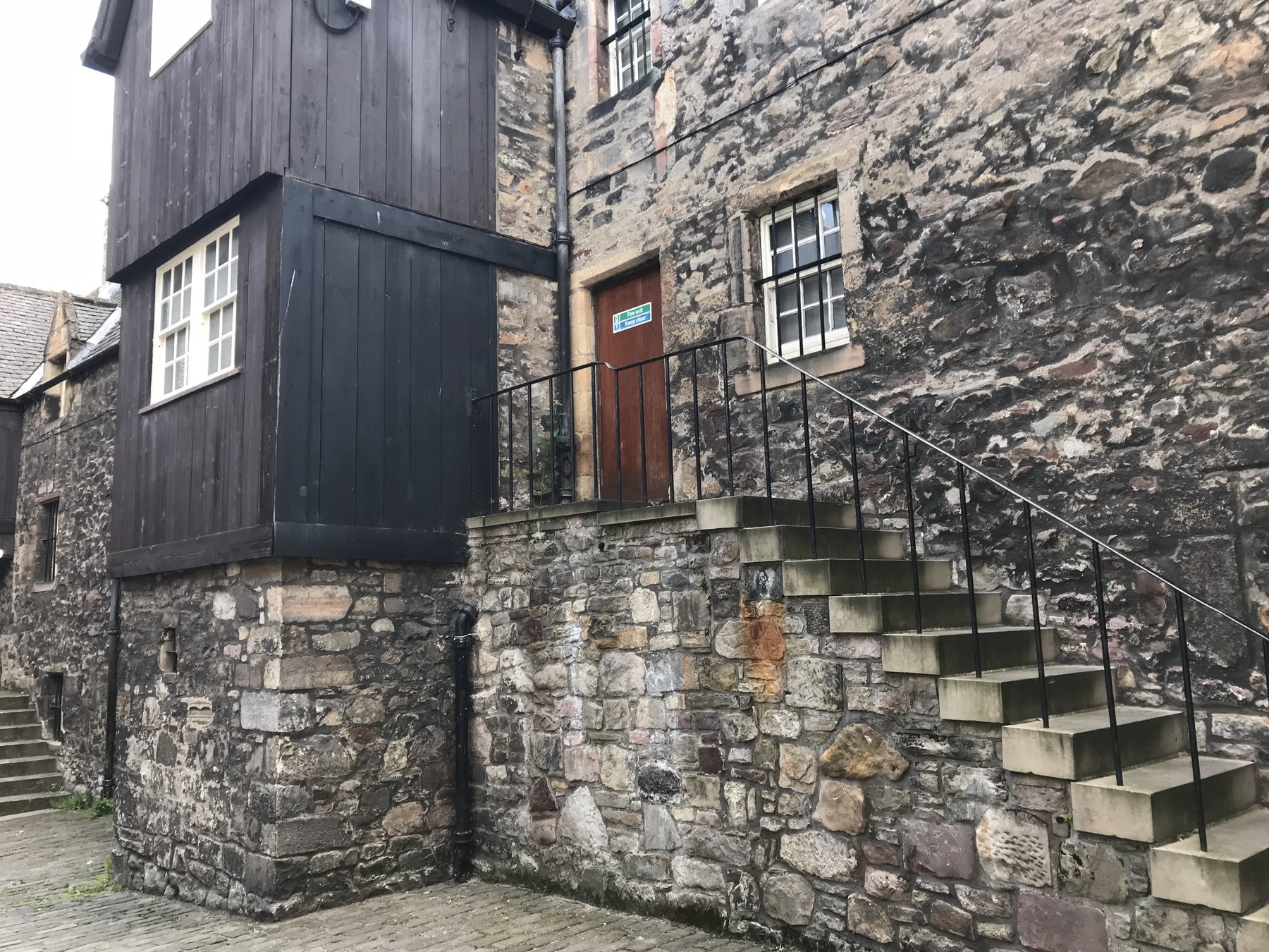 Stone steps leading to the dark wooden frontage used for Jamie’s printshop at Bakehouse Close