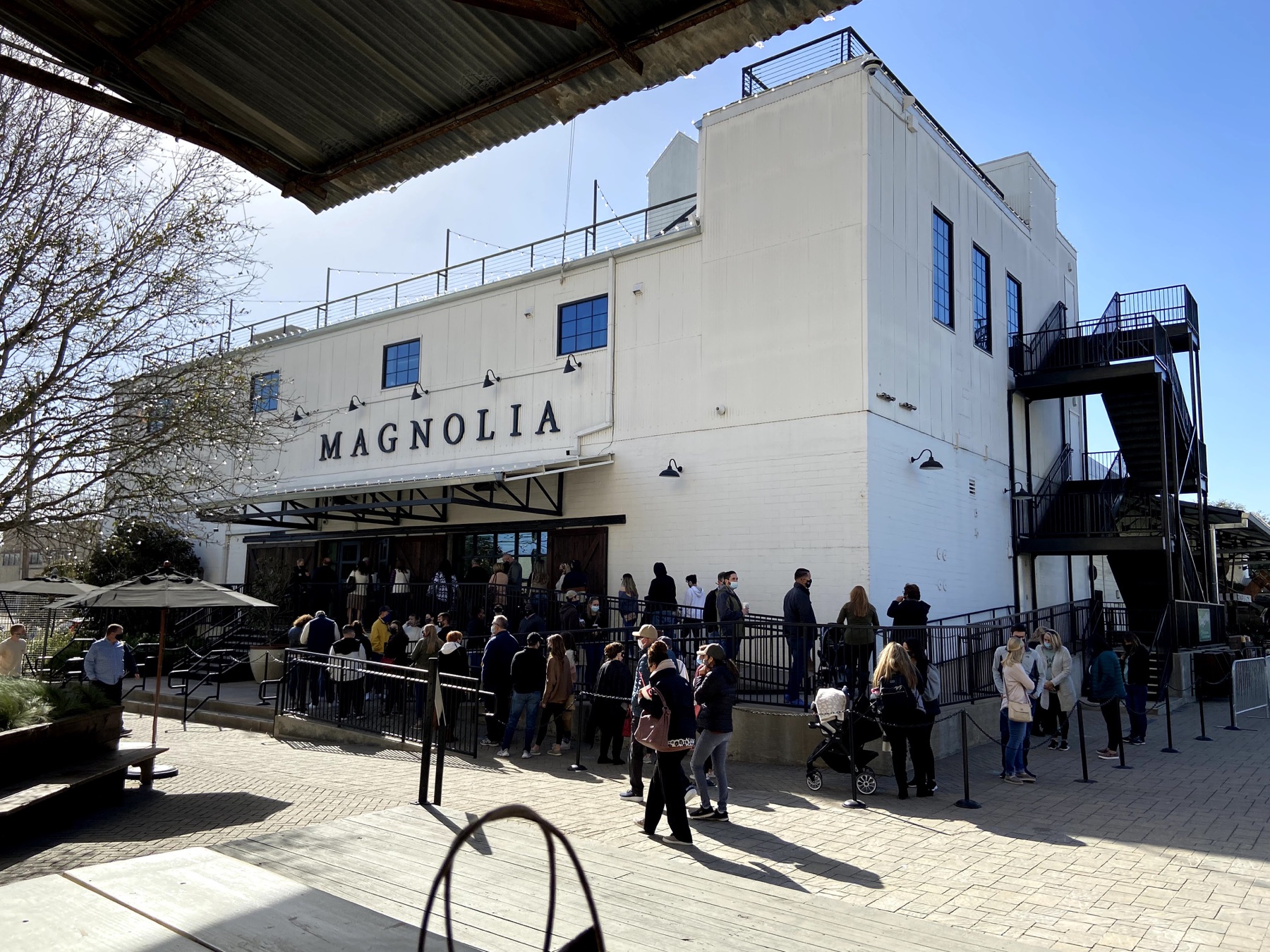 Visitors waiting outside the white Magnolia Market building in Waco