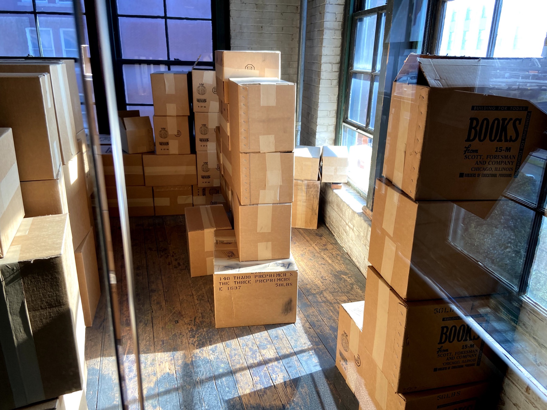 Re-created stacks of book cartons beside windows on the sixth floor of the former Texas School Book Depository