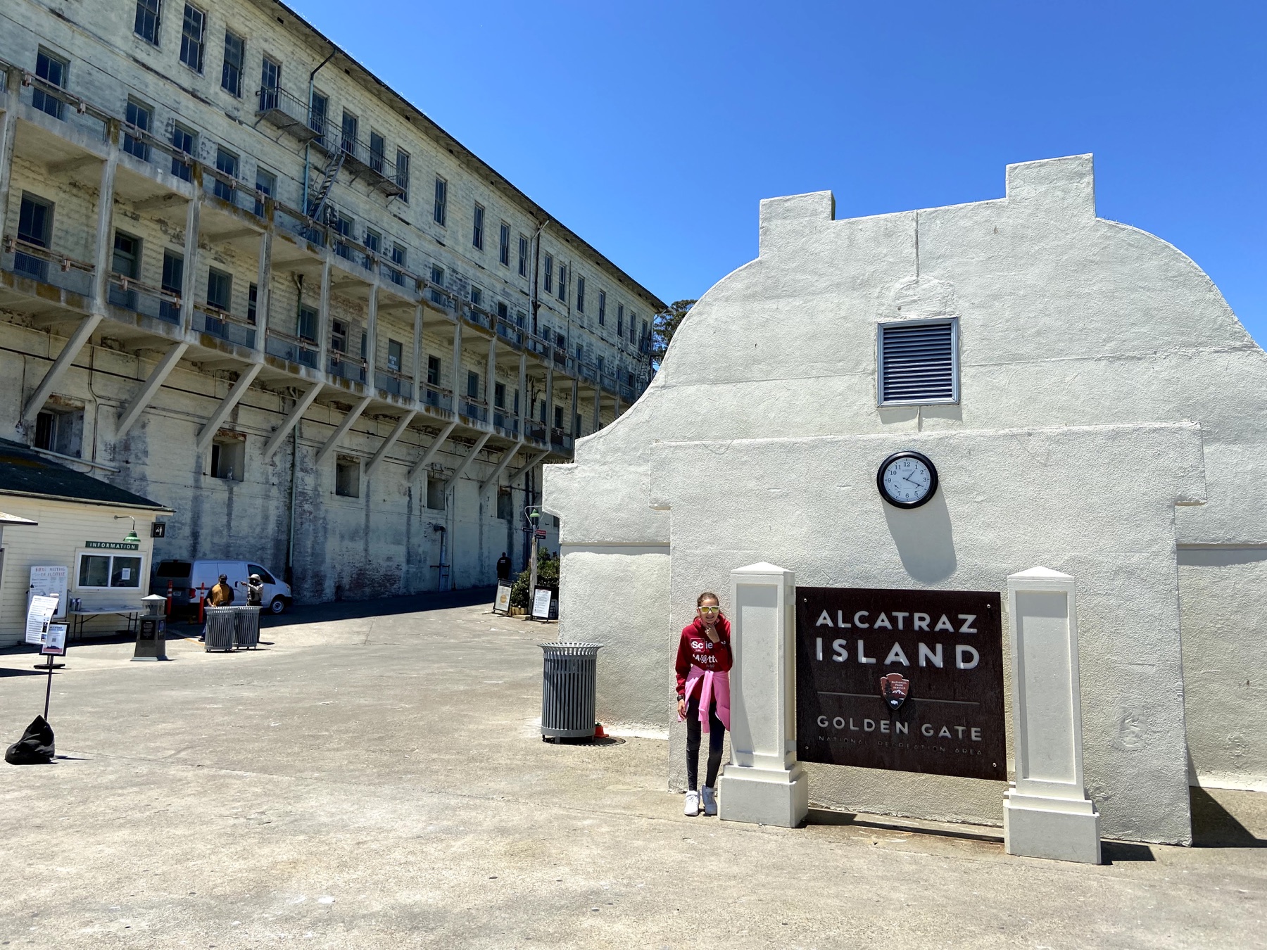 Alcatraz Island sign and historic cellhouse building with a child standing nearby