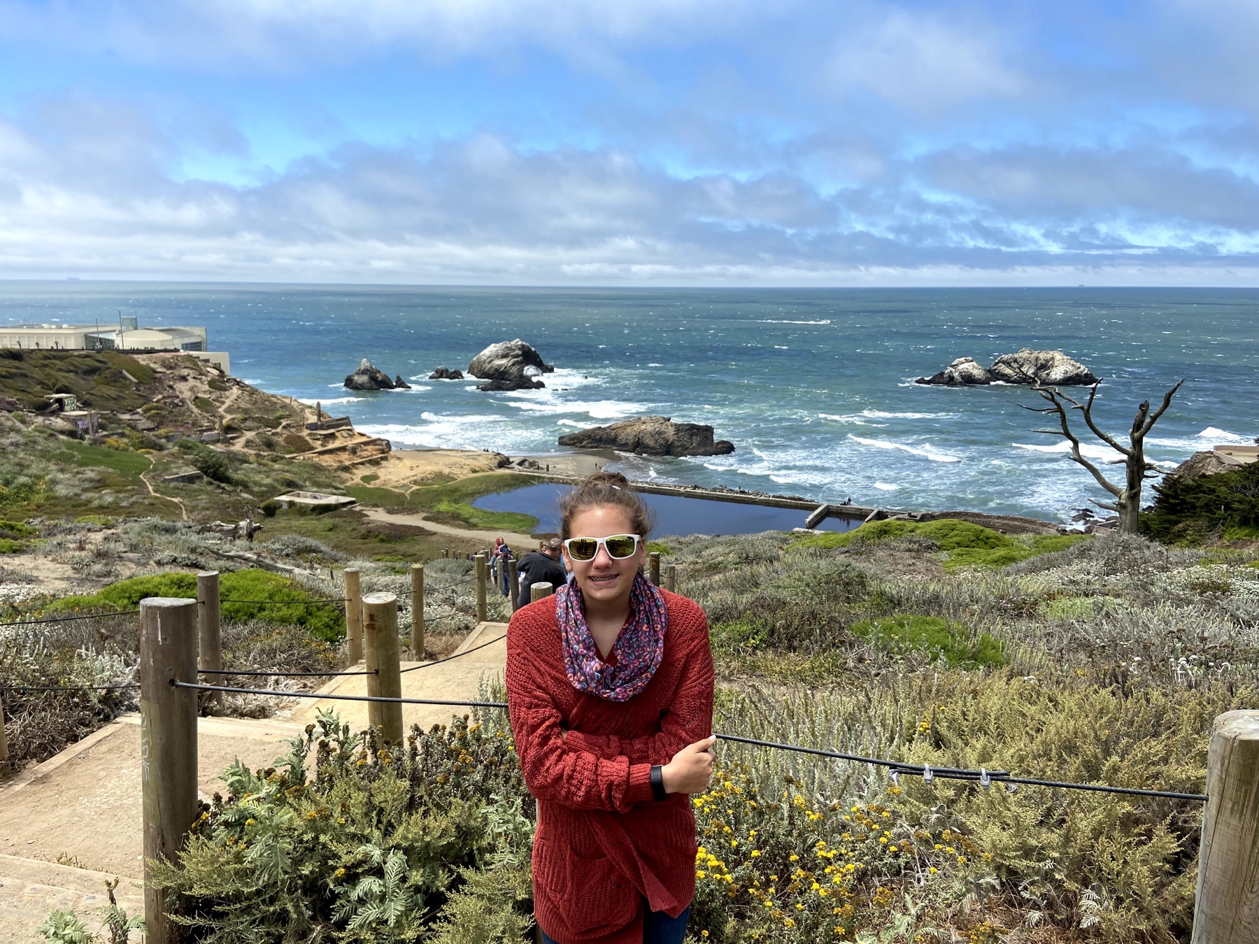 A daughter overlooking the rocky Pacific shoreline and Sutro Baths ruins