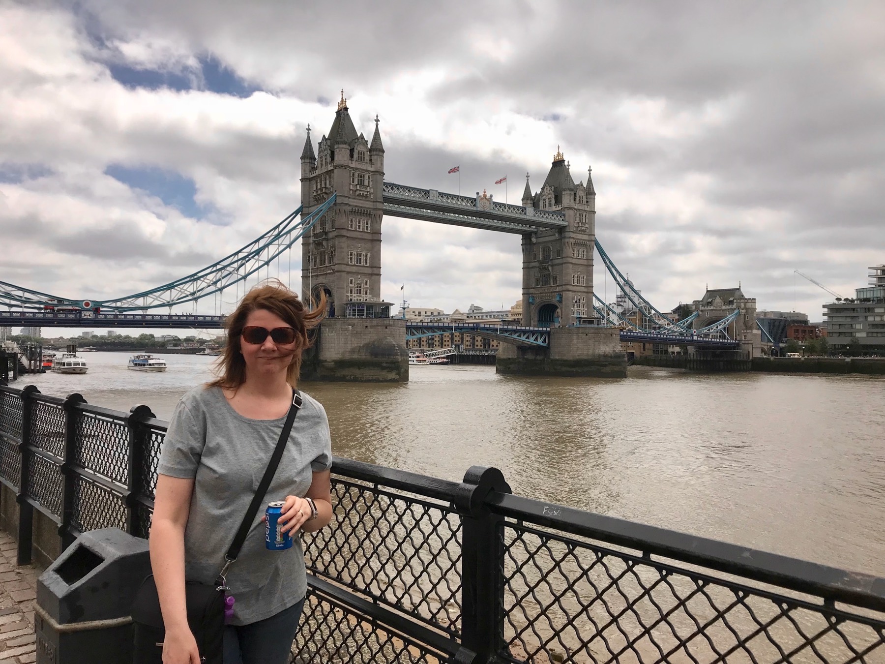 Angela standing beside the River Thames with Tower Bridge behind her