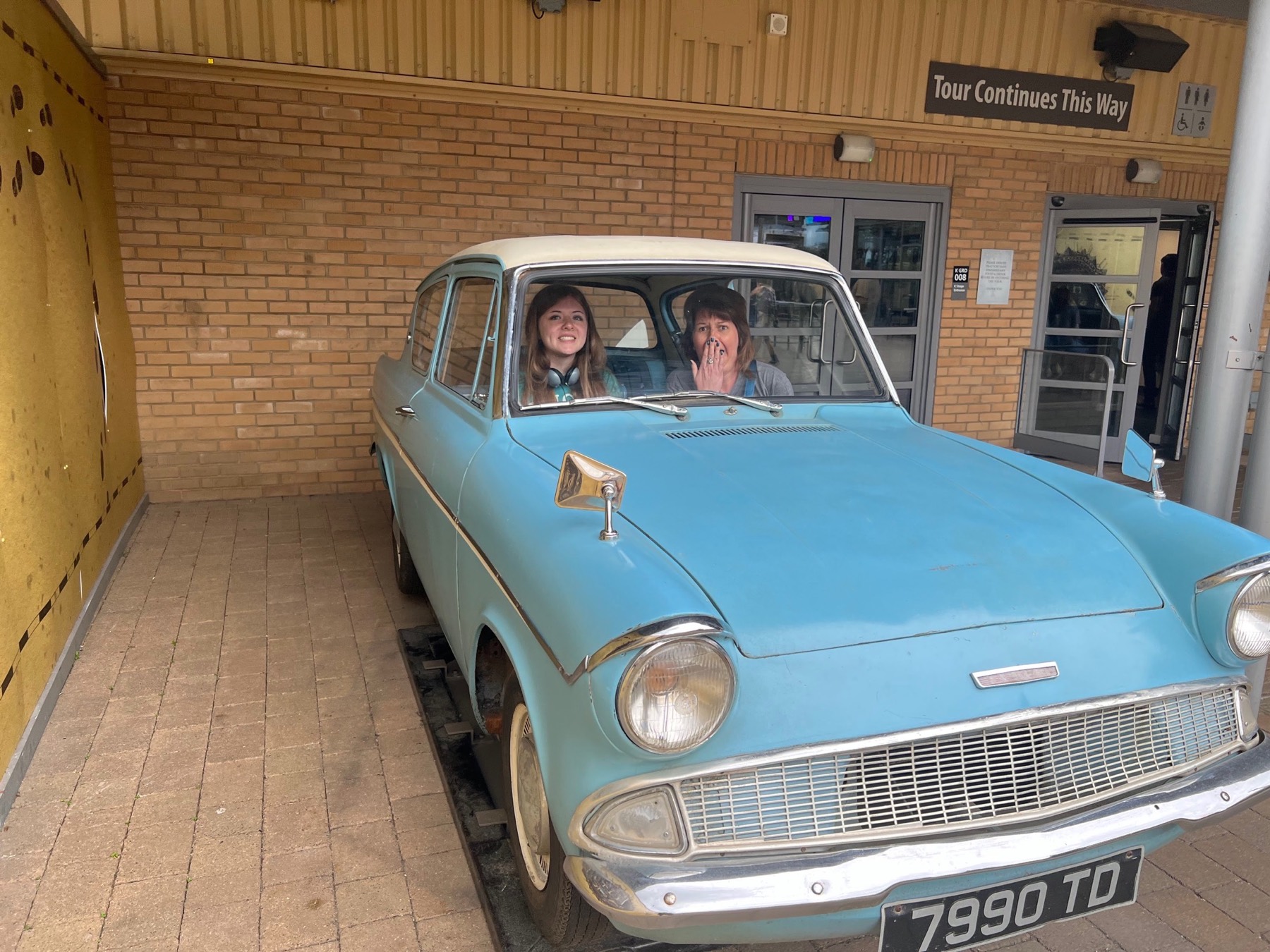 Madison and Angela posing inside the blue Ford Anglia at the Warner Bros. Studio Tour