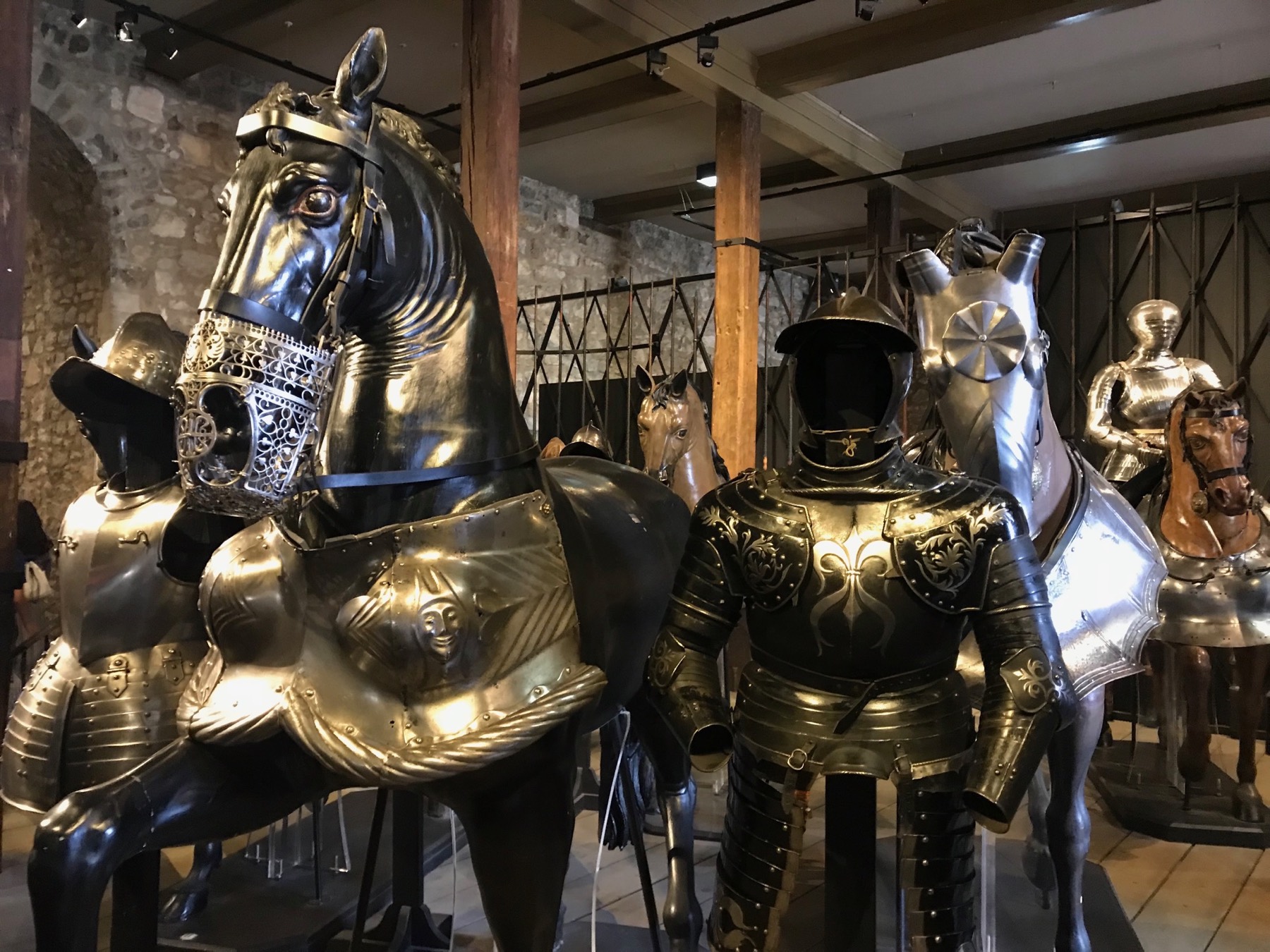 An ornate suit of royal armour displayed on horseback inside the Tower of London