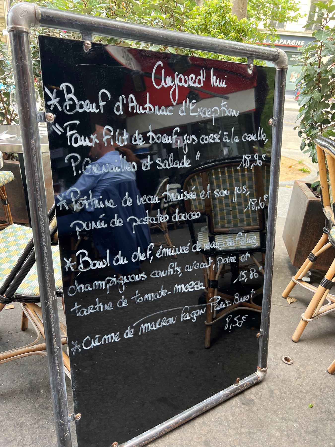 A handwritten French lunch menu on a chalkboard outside a Paris café