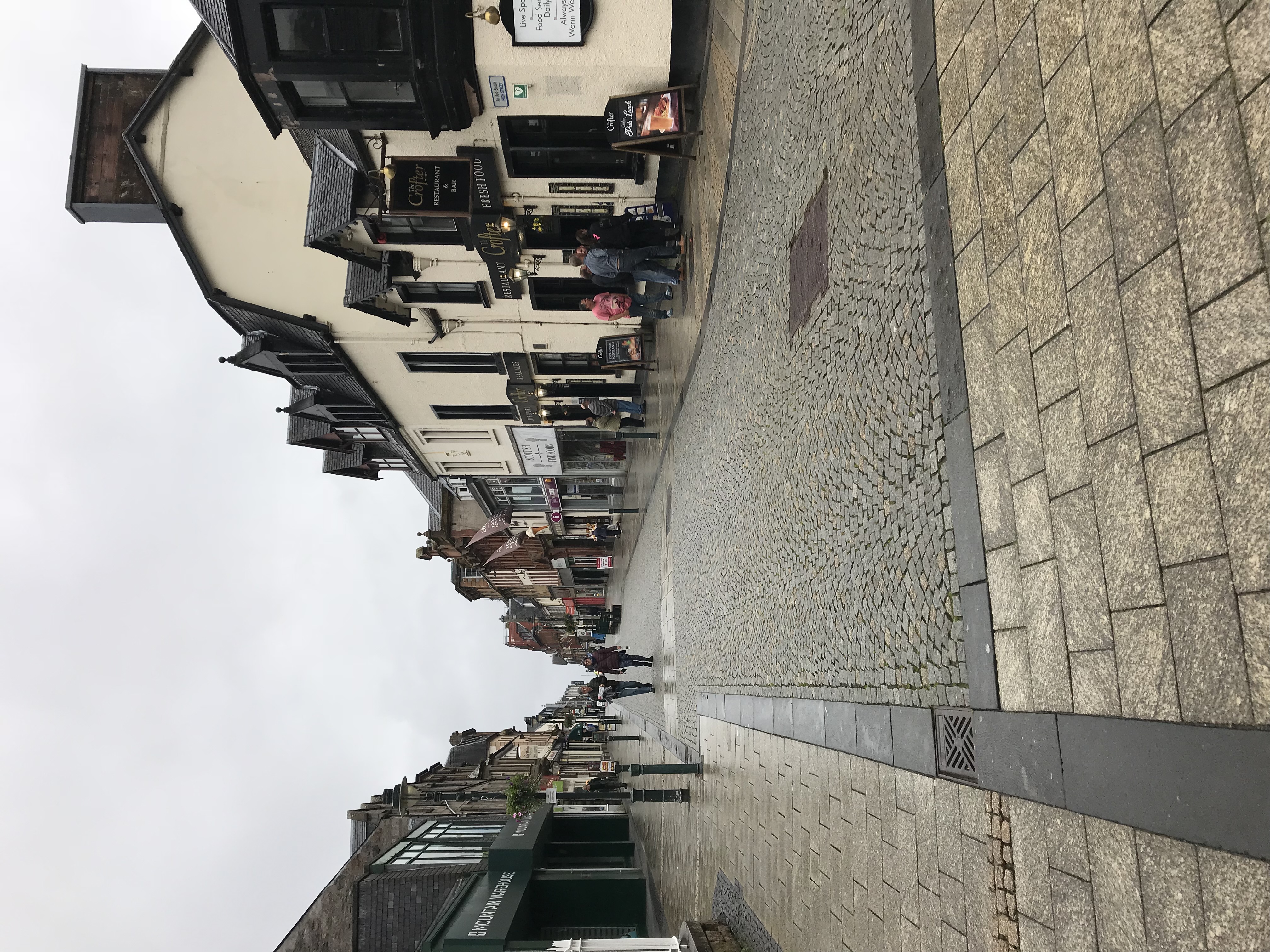 Shops and pedestrians along Fort William High Street in the Scottish Highlands