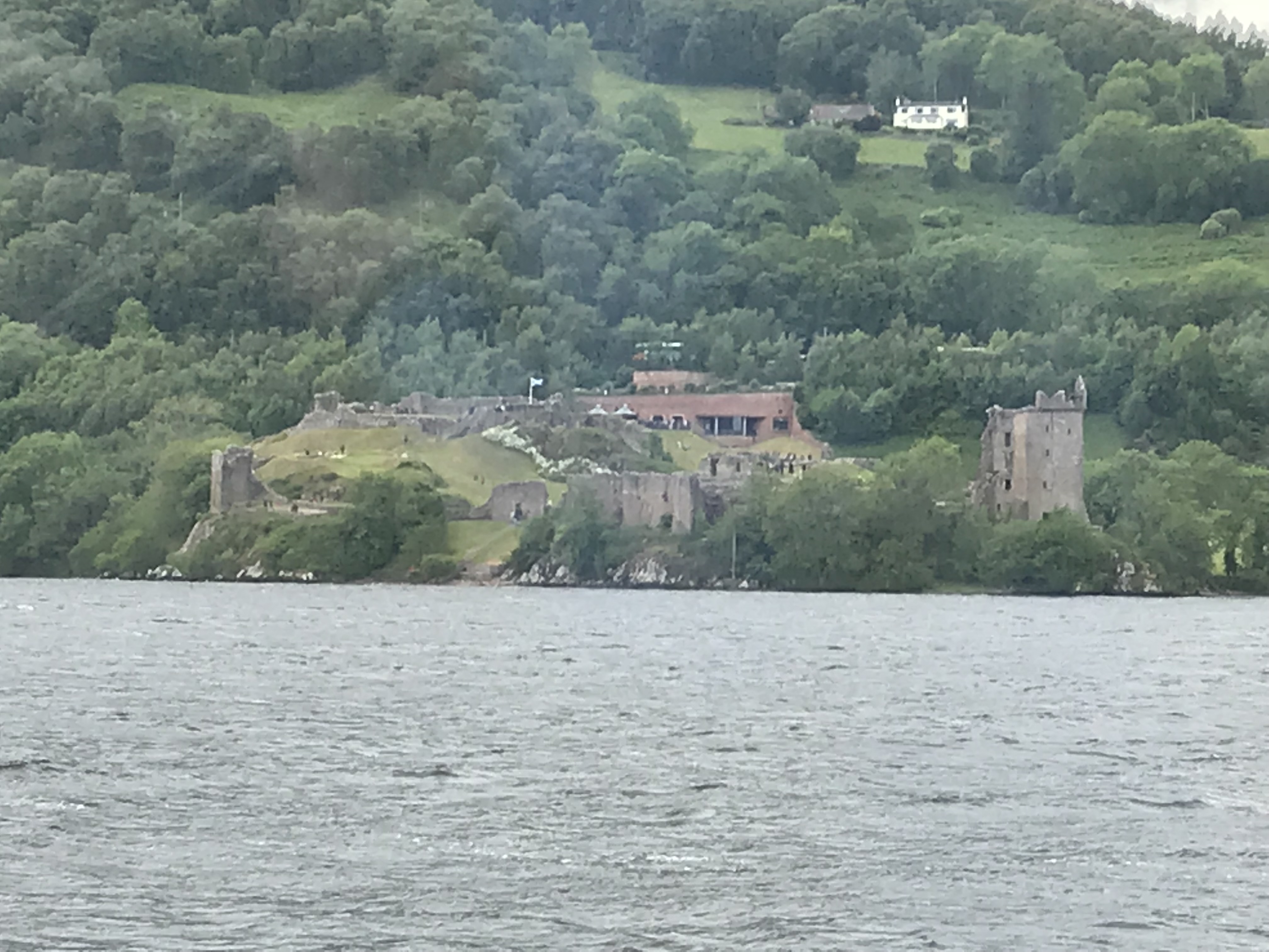 Dark water and green Highland slopes seen from a boat on Loch Ness