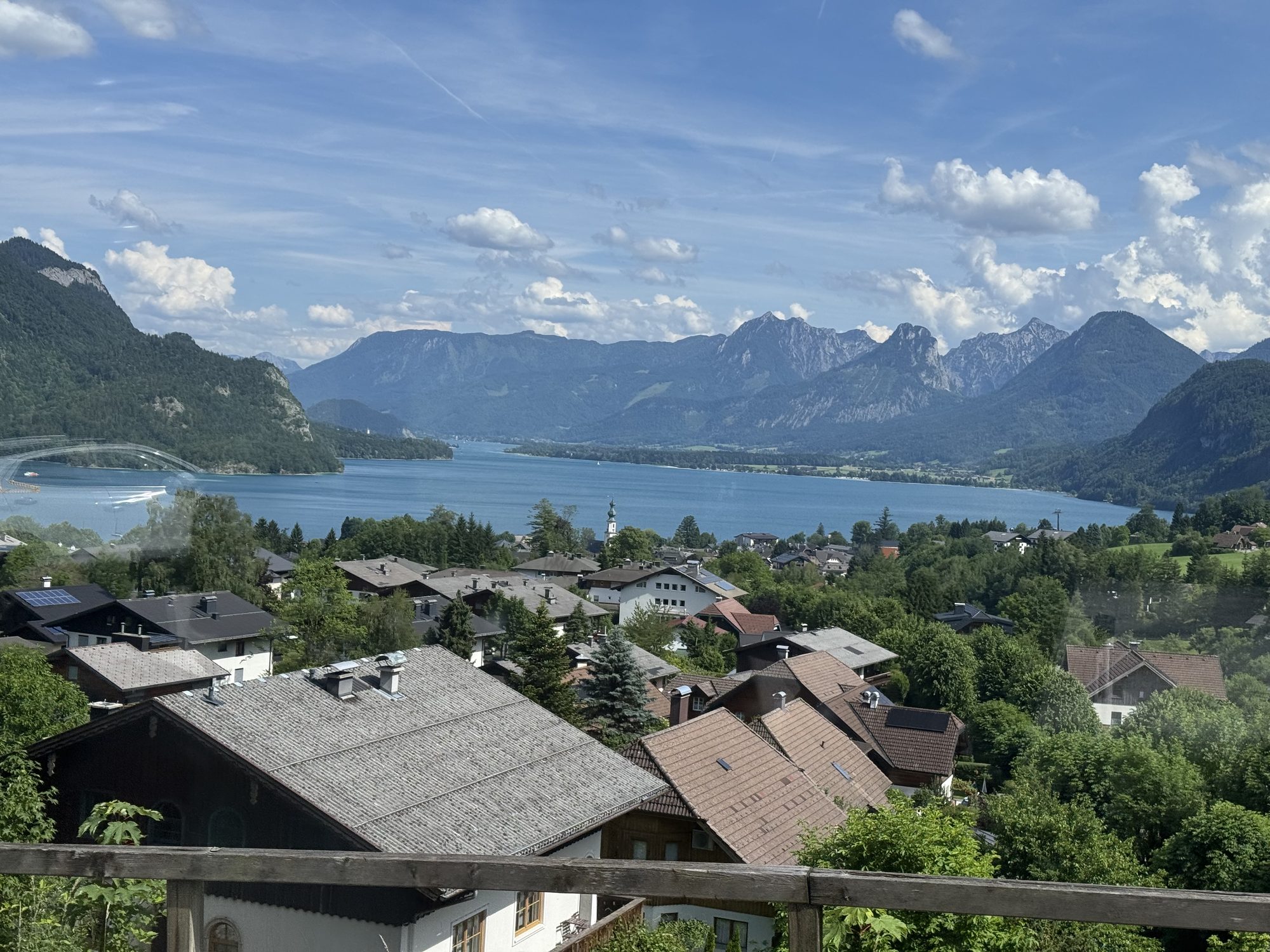 A blue lake surrounded by green mountains in the Salzkammergut, viewed from the tour bus
