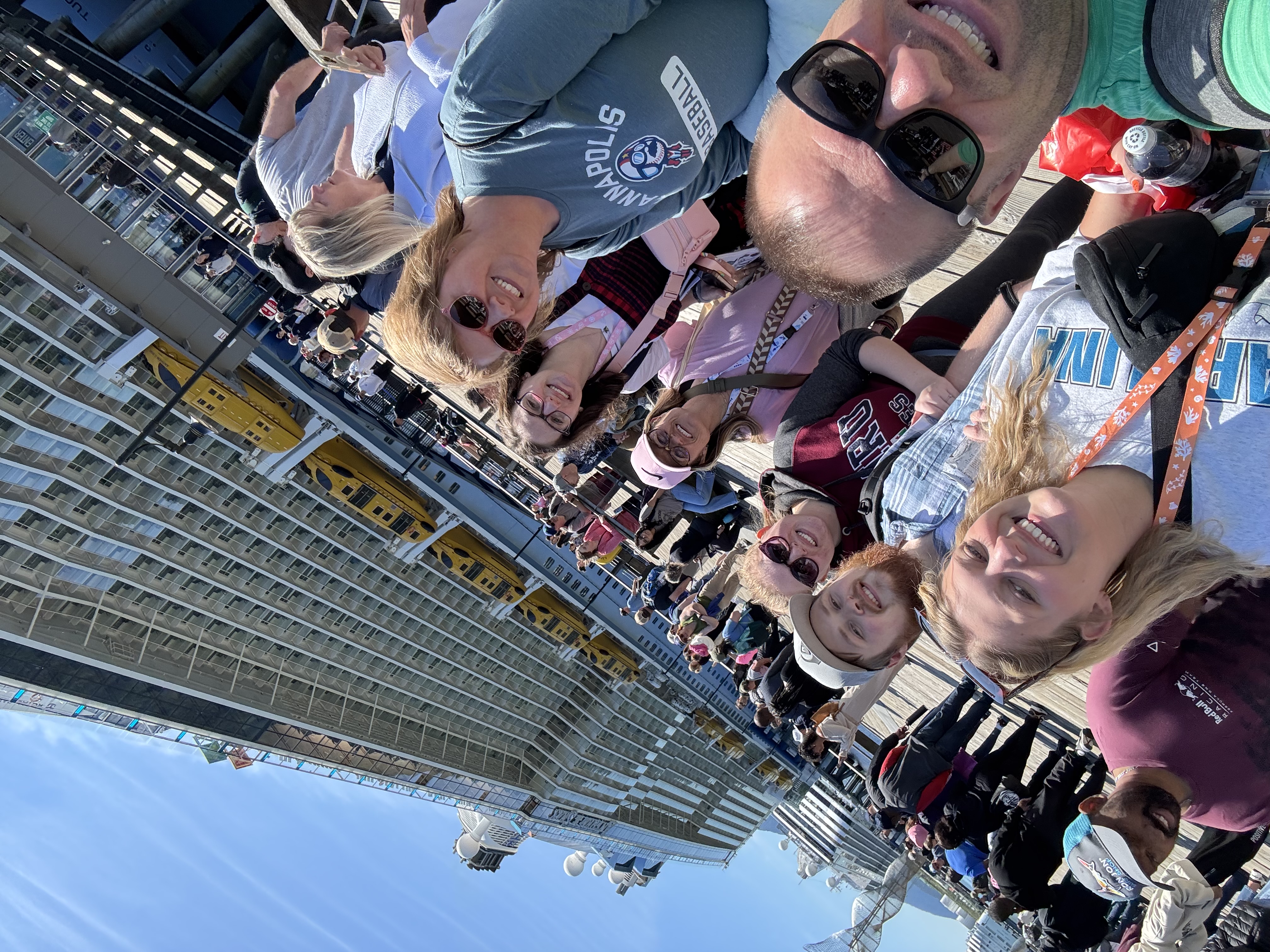 Angela, Brian, and family members smiling together on the Juneau cruise pier beside Anthem of the Seas
