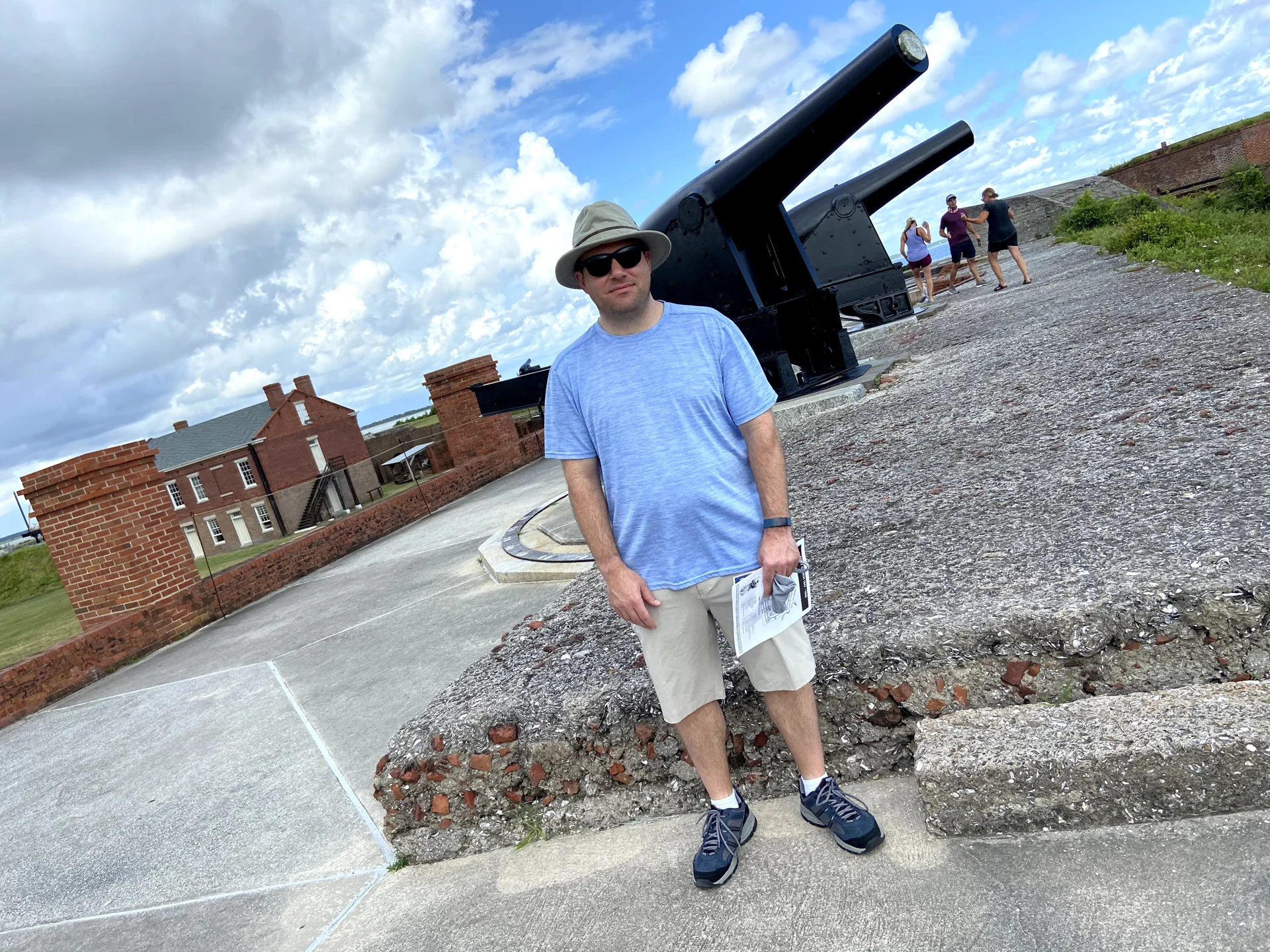 A family member standing beside a large historic cannon at Fort Clinch