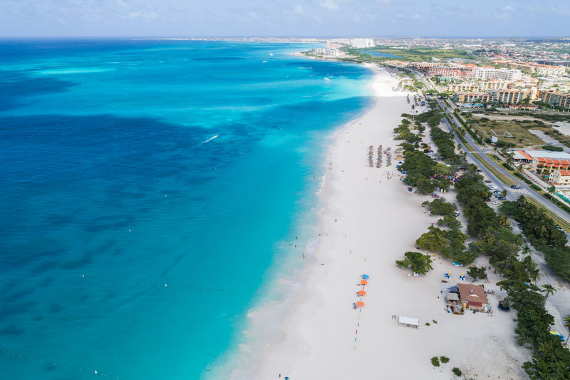 Aerial view of white sand and turquoise water at Eagle Beach in Aruba