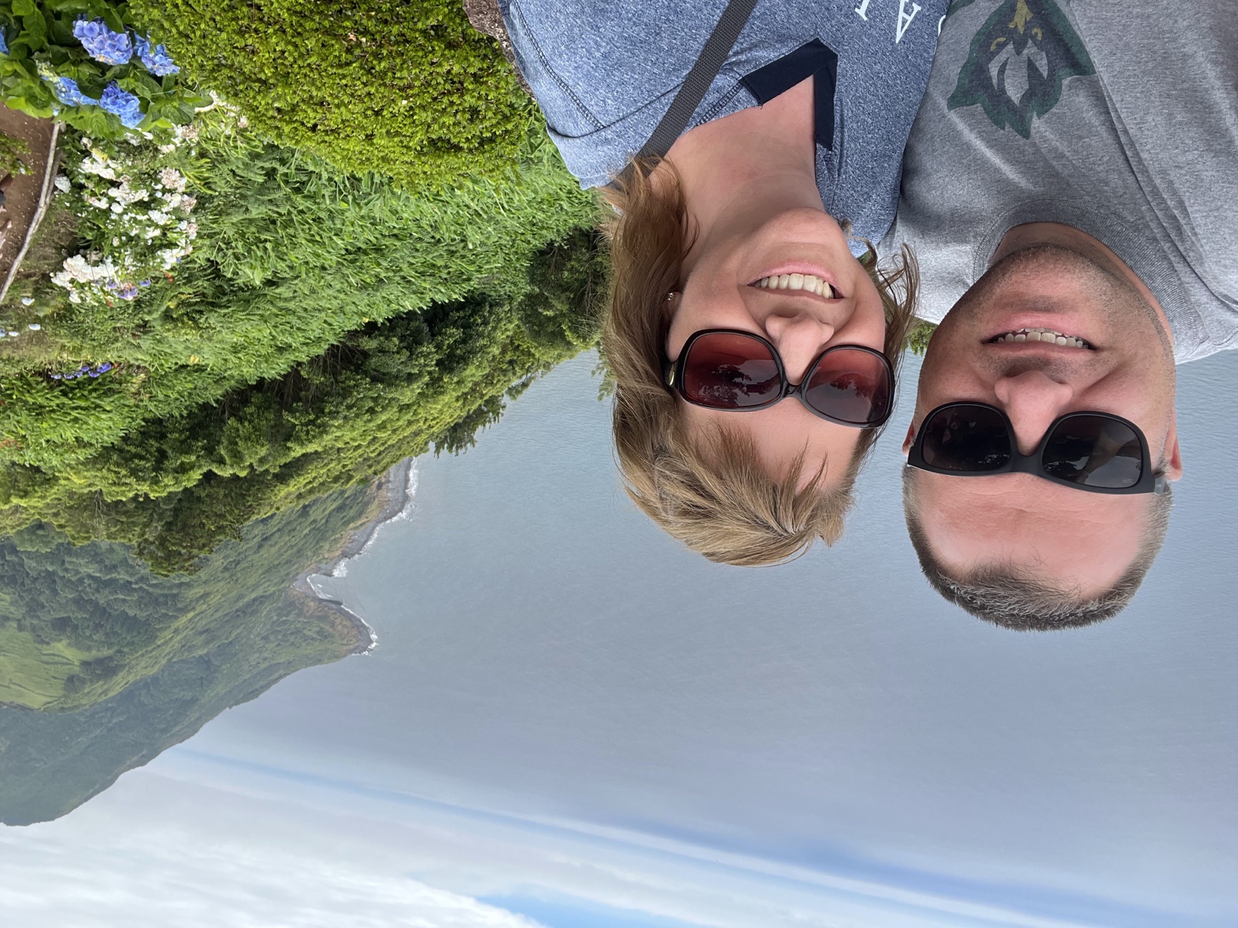 Angela and Brian smiling at a coastal overlook above the Atlantic