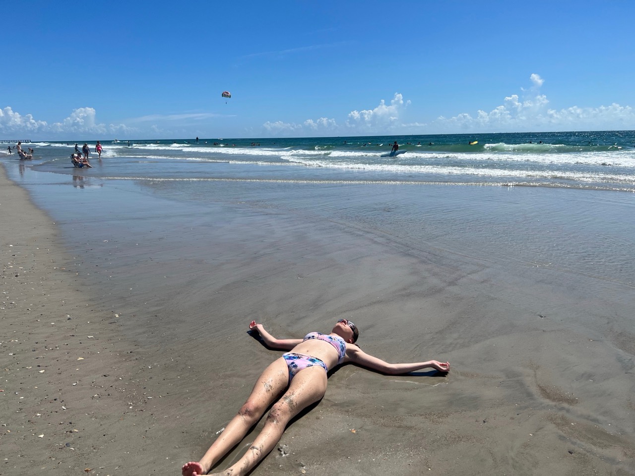 A traveler relaxing on the wet sand beside the ocean at Wrightsville Beach, North Carolina