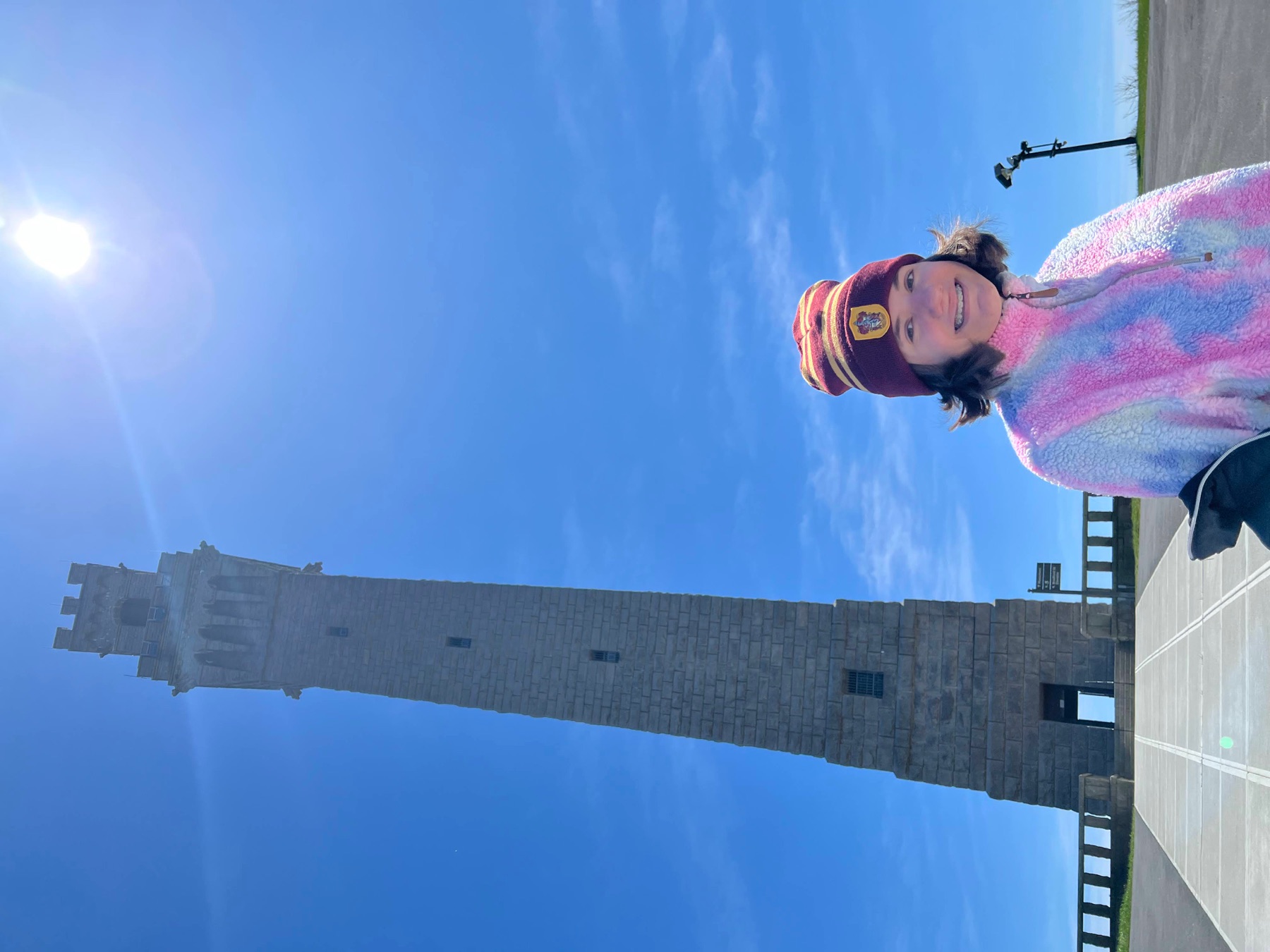 Smiling teenage girl standing beside the Pilgrim Monument in Provincetown
