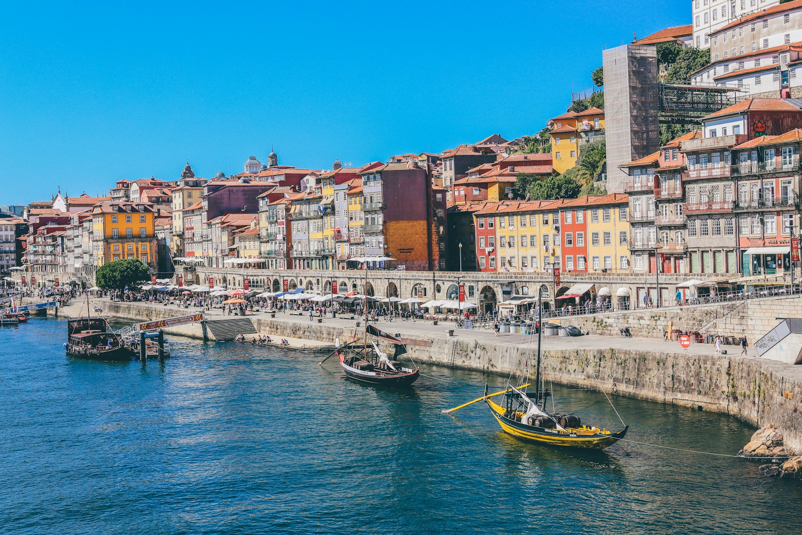 Traditional boats on the Douro River below Porto’s colorful waterfront buildings