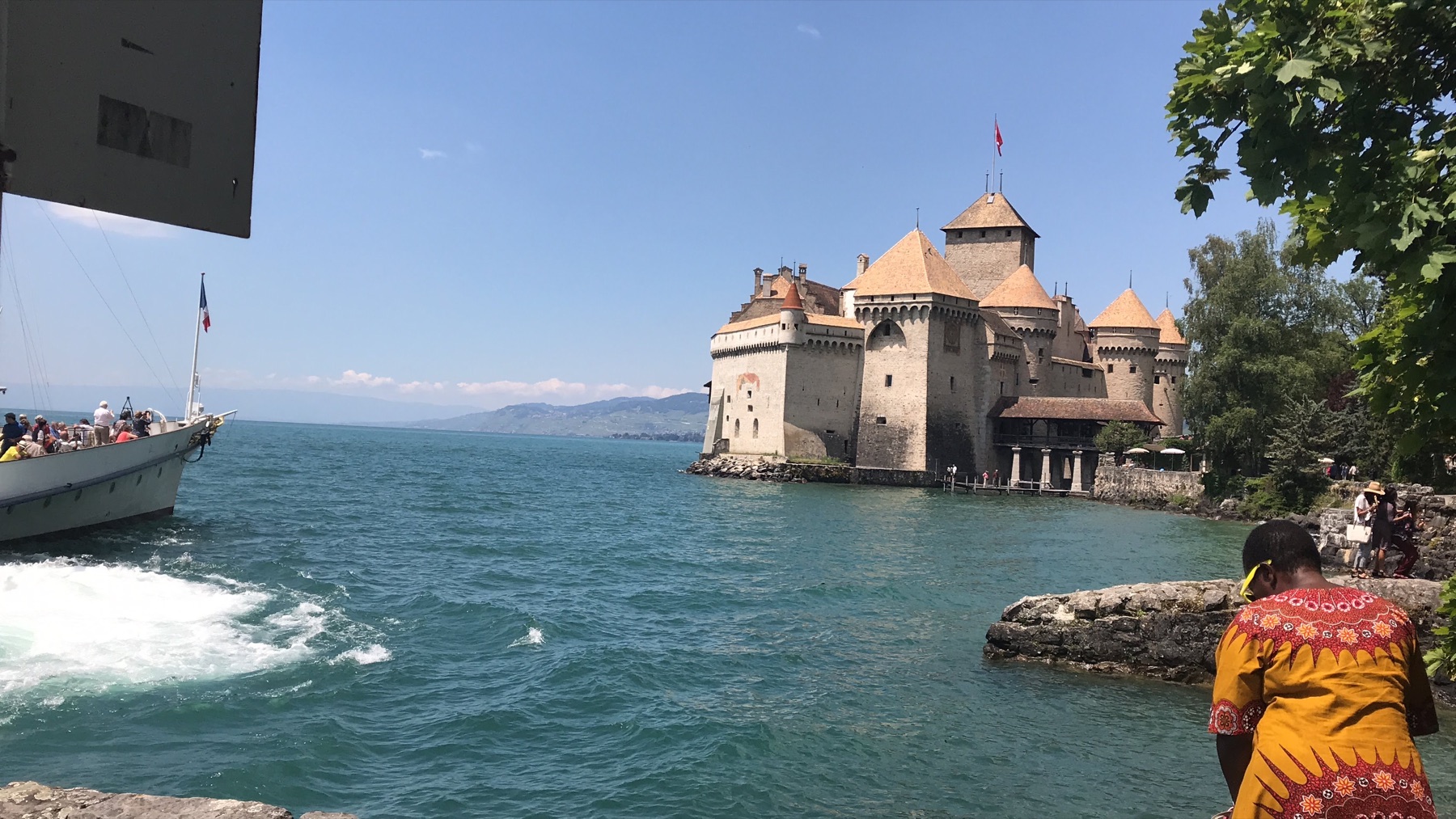 Château de Chillon beside Lake Geneva as a passenger boat pulls away