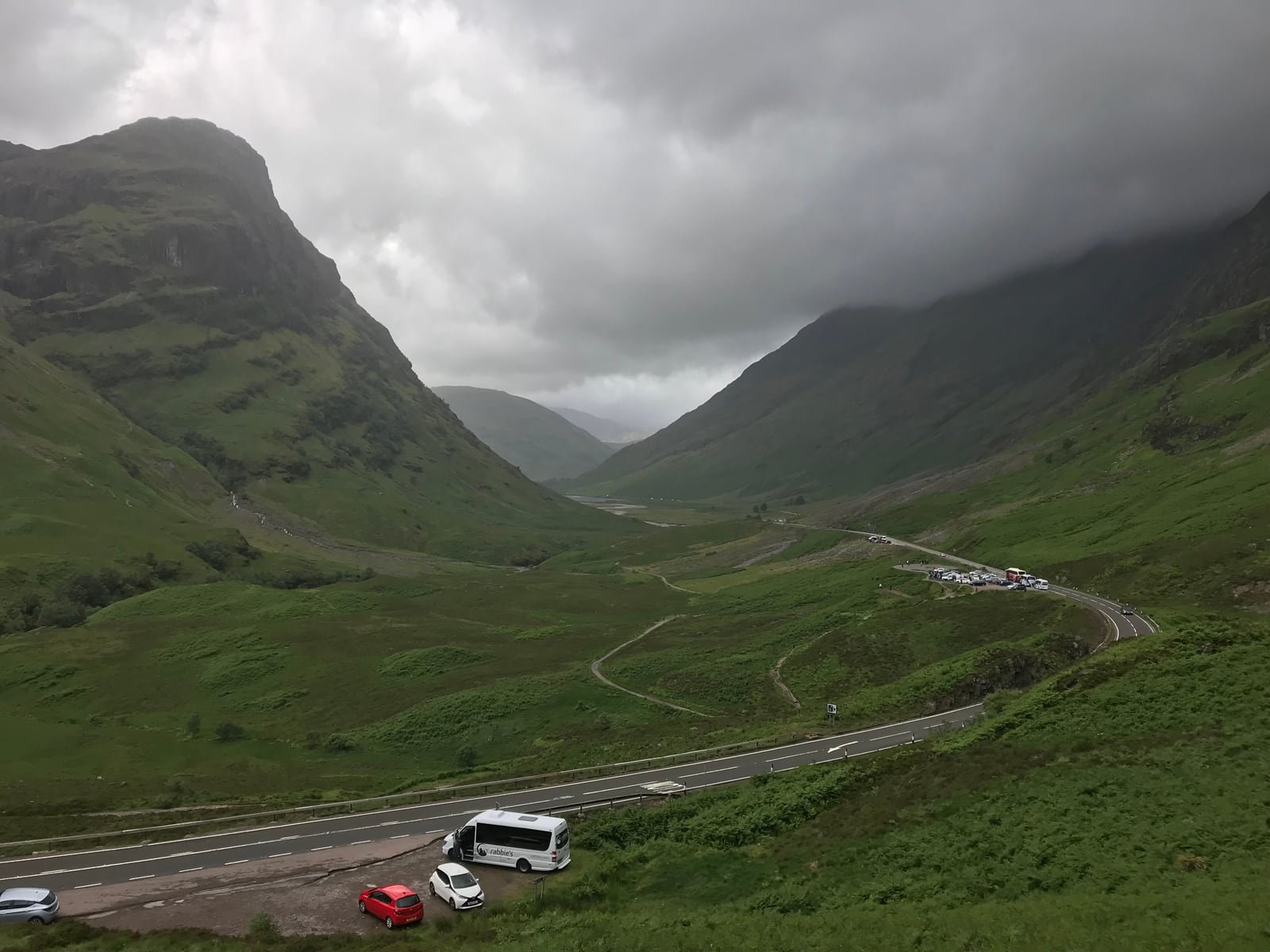 Steep green mountains framing the Glencoe valley beneath low gray clouds