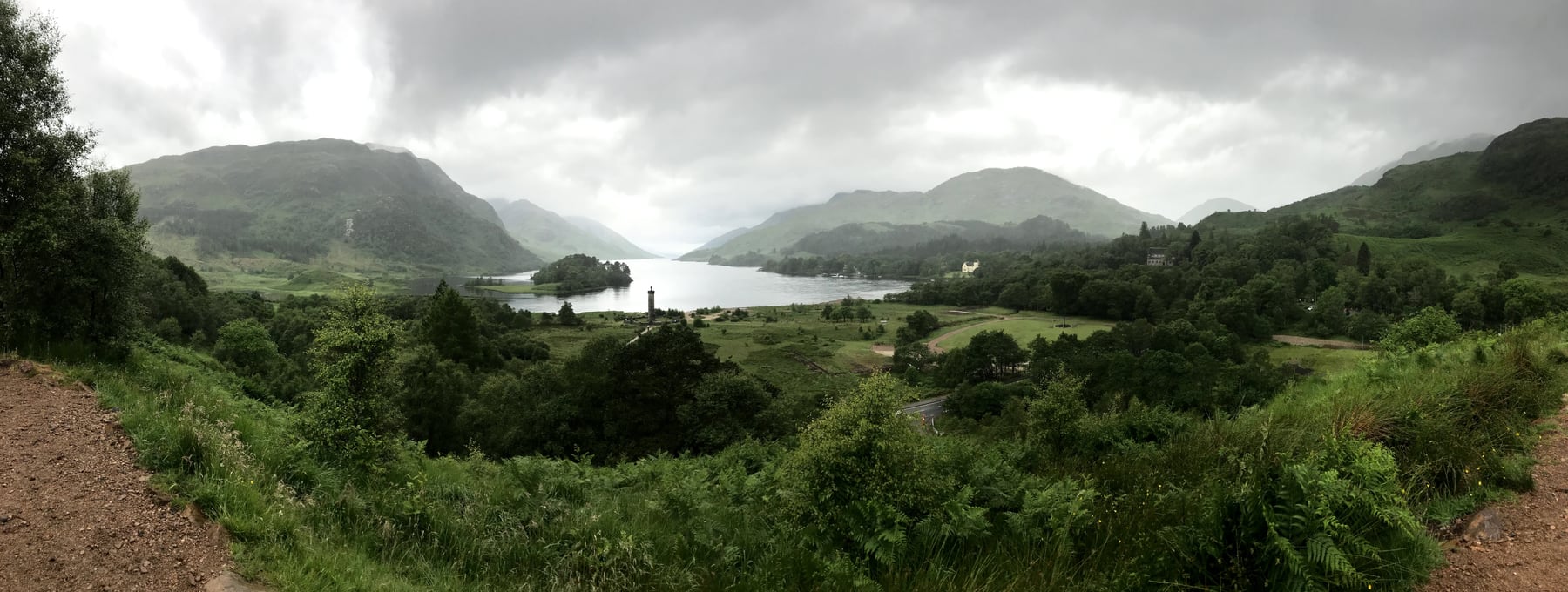 Loch Shiel stretching between green mountains with Glenfinnan Monument visible near the shore