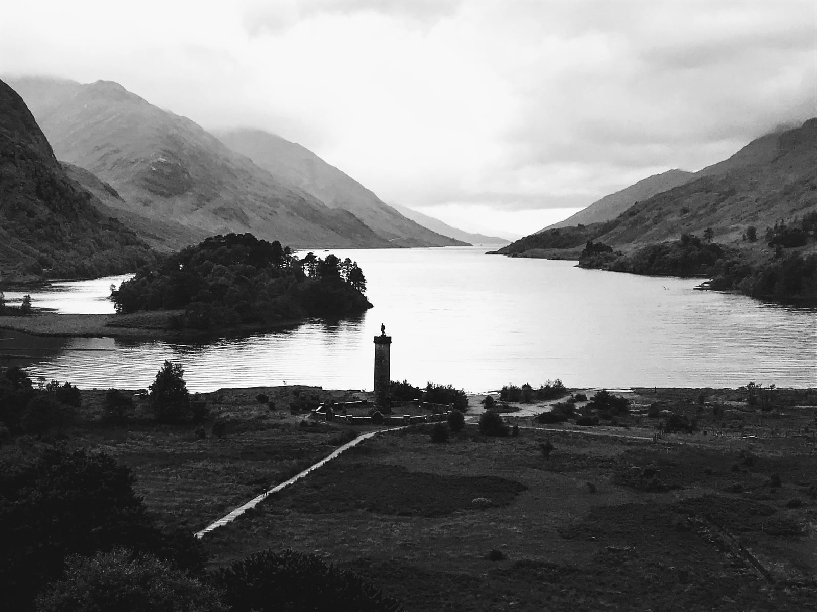 Glenfinnan Monument standing at the head of Loch Shiel between steep Highland mountains