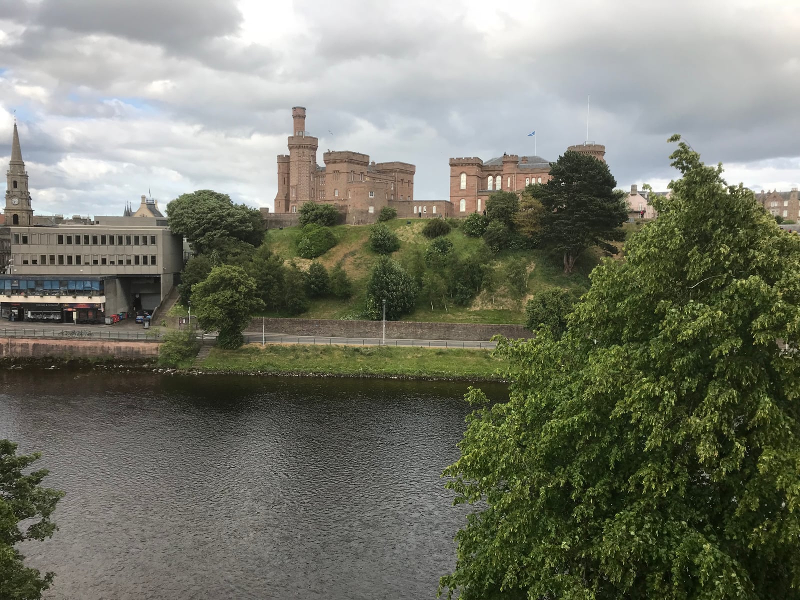 Inverness Castle standing above trees on the opposite bank of the River Ness
