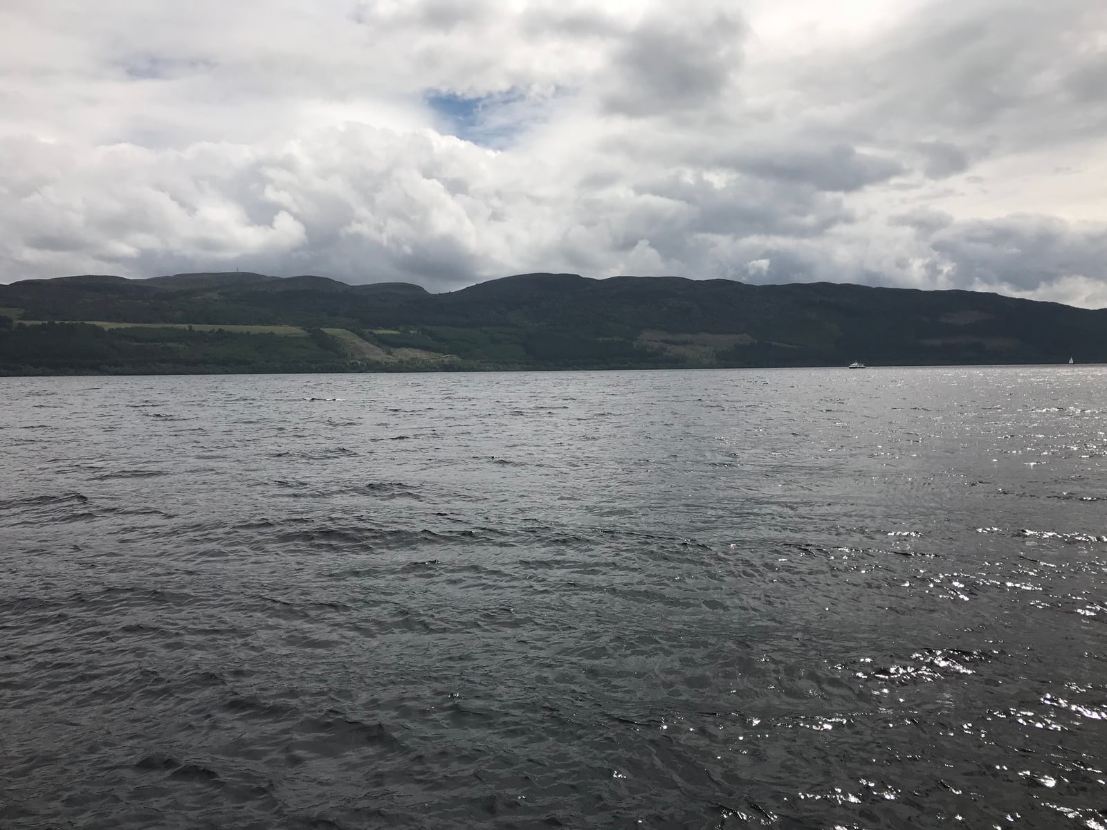 Dark open water of Loch Ness beneath cloud-covered Highland hills
