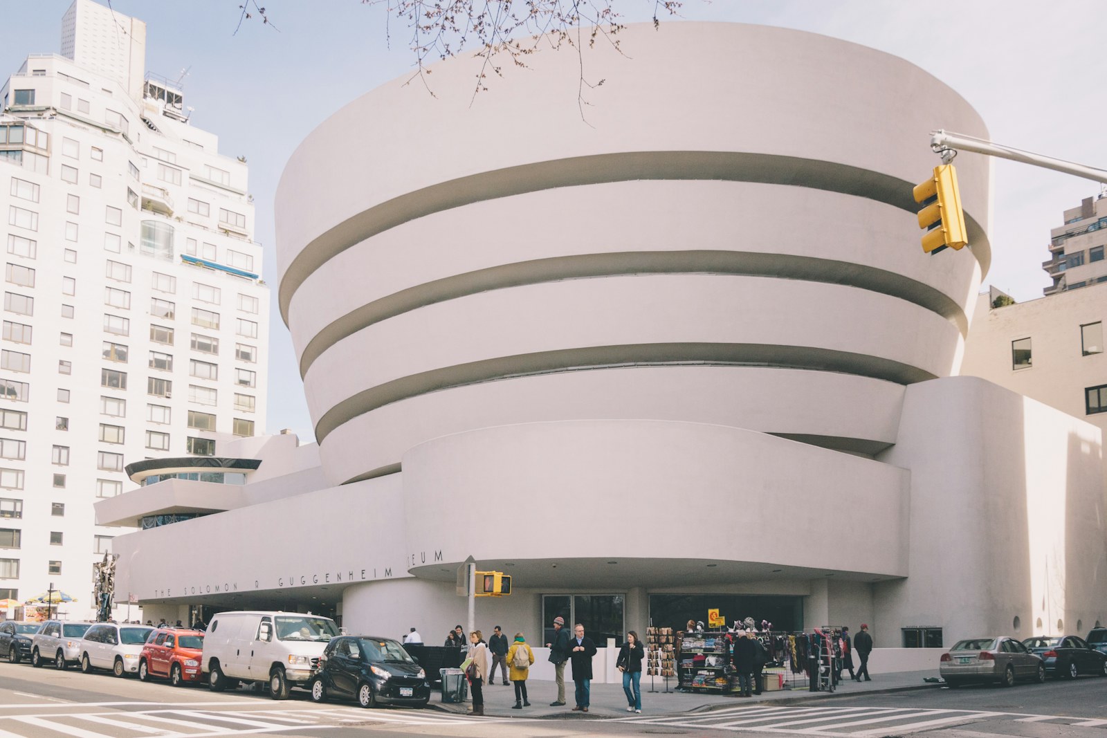 The white curved exterior of the Guggenheim Museum beside a Manhattan intersection