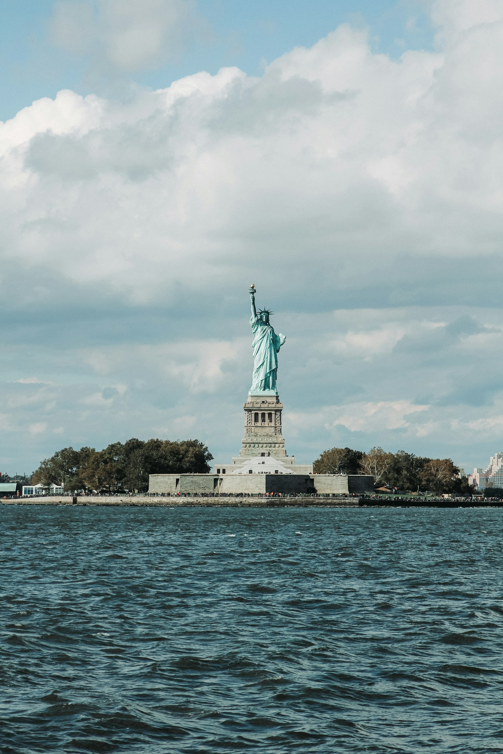 Statue of Liberty rising above its pedestal across the waters of New York Harbor