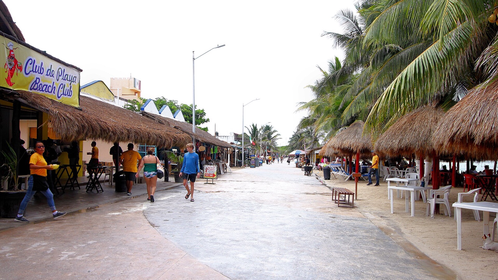 Pedestrian waterfront in Mahahual with restaurants on one side and the beach on the other