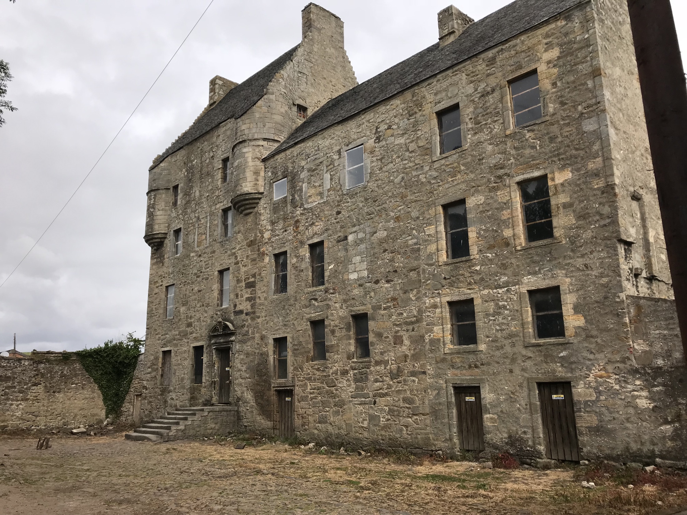 The weathered stone façade of Midhope Castle seen from its courtyard