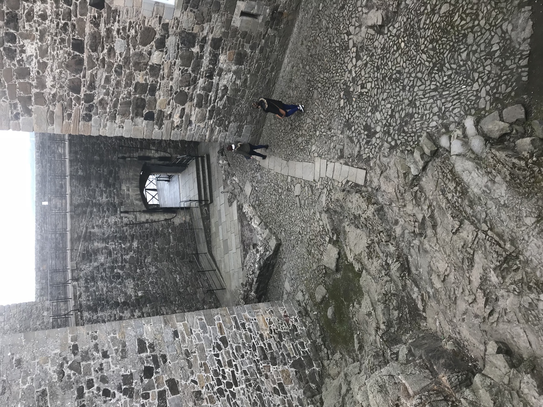 Stone walls, cobbled ground, and an arched passage inside Blackness Castle
