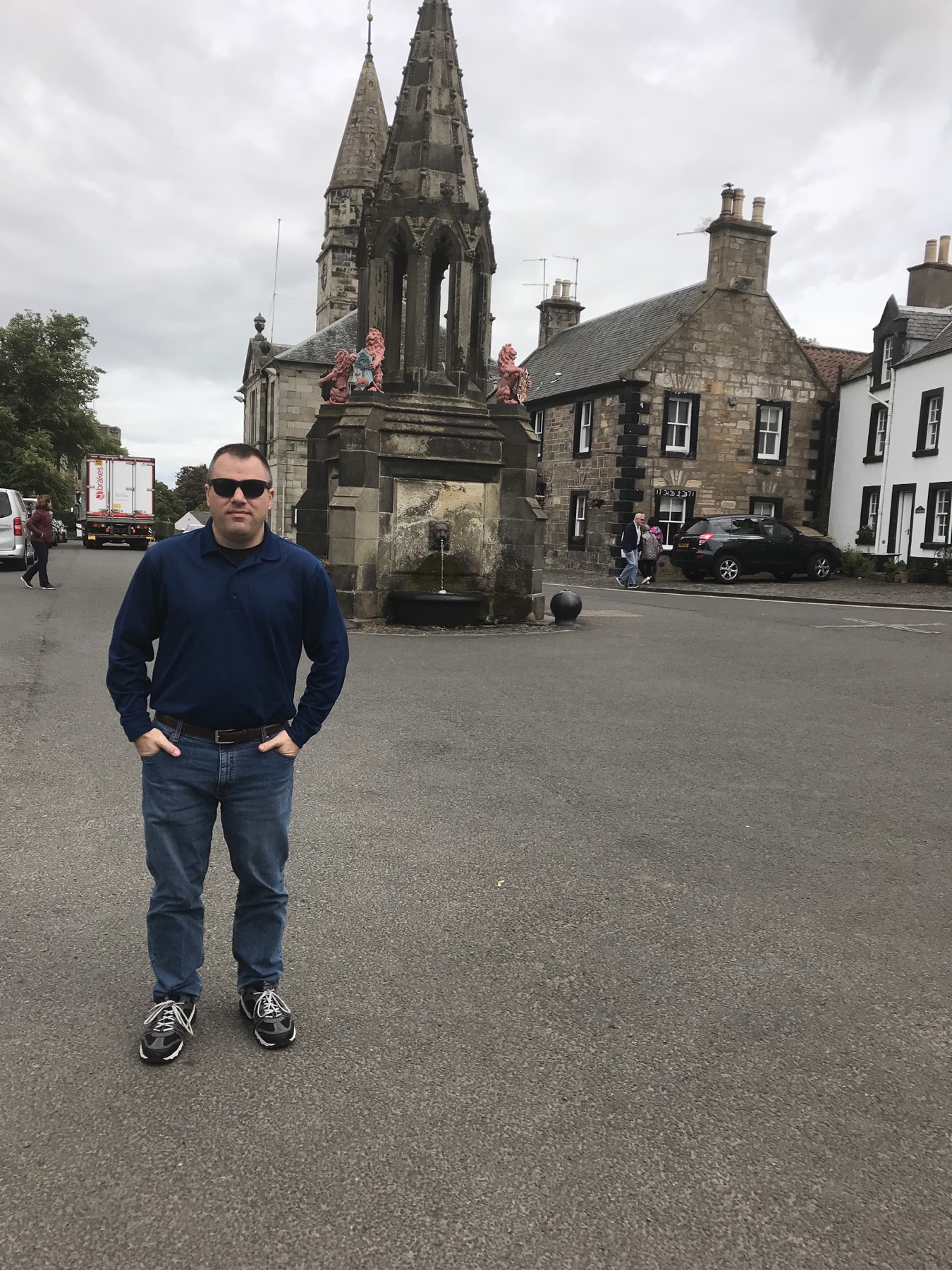 A traveler standing near Bruce Fountain in Falkland village square
