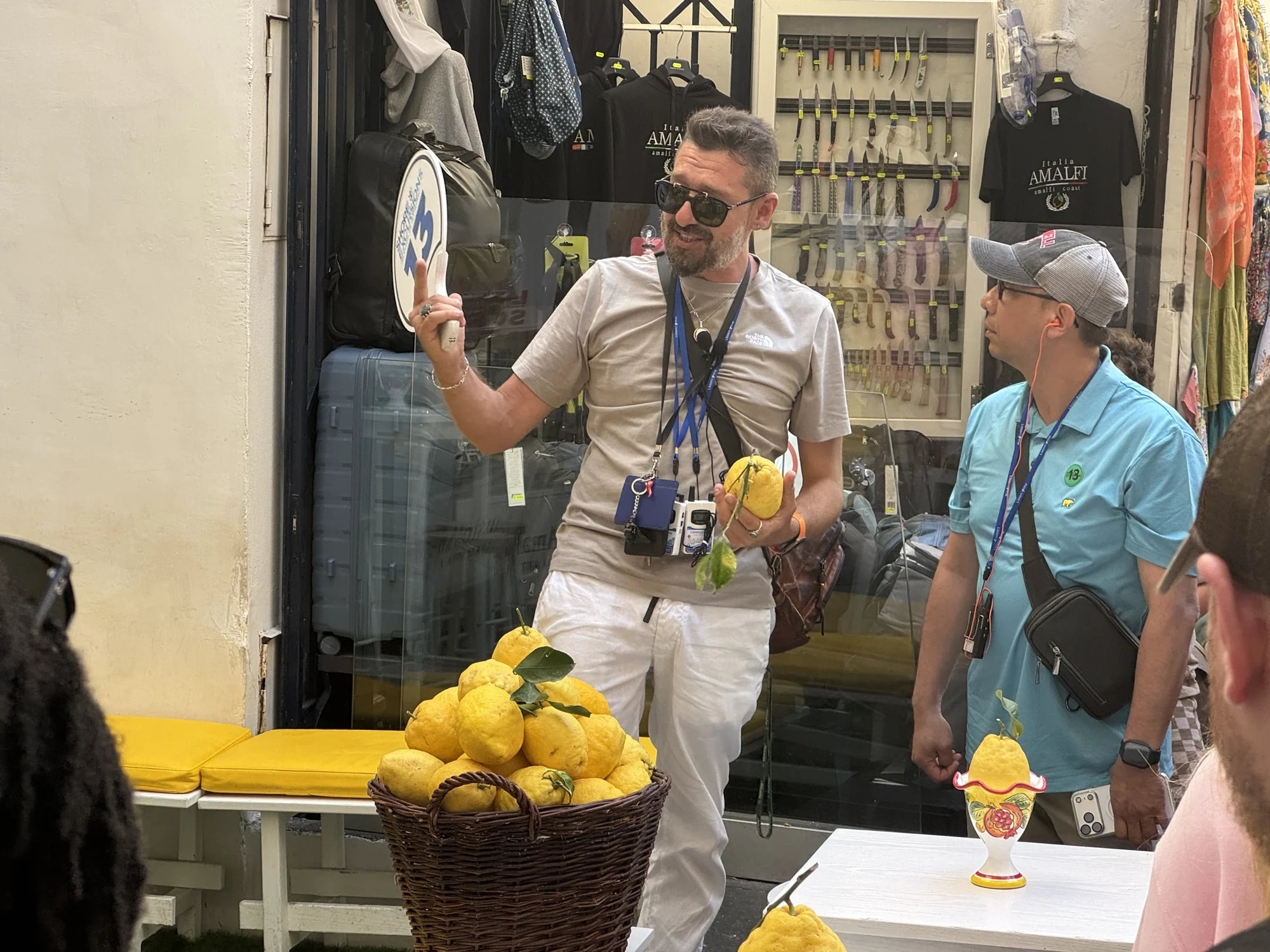 Large lemons piled in a basket outside an Amalfi shop as visitors watch a presentation