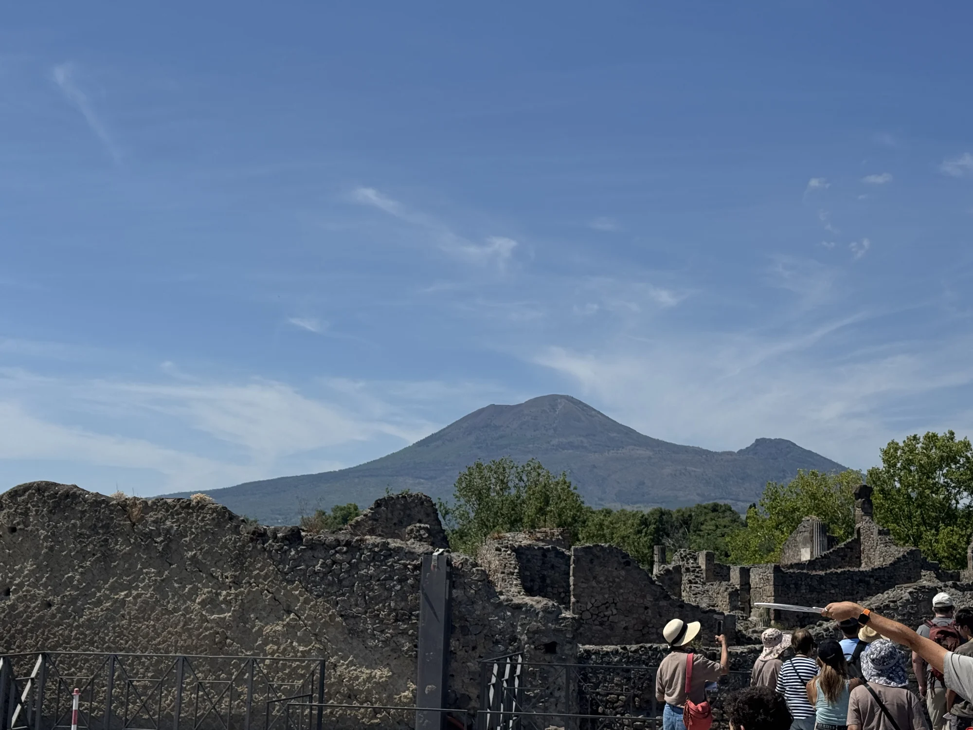 Mount Vesuvius rising behind Pompeii’s stone ruins beneath a blue sky