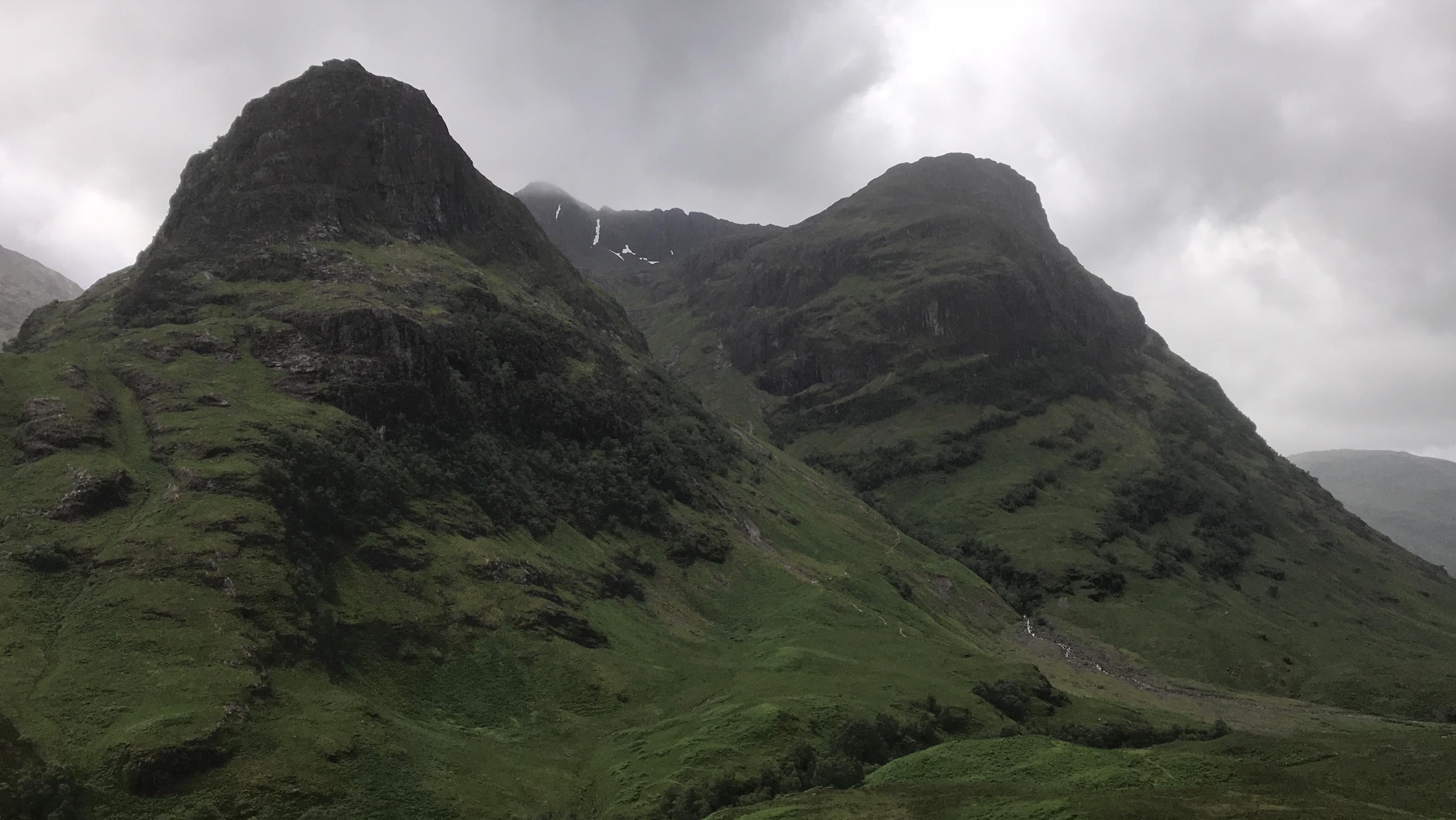The steep green and rocky slopes of the Three Sisters in Glencoe
