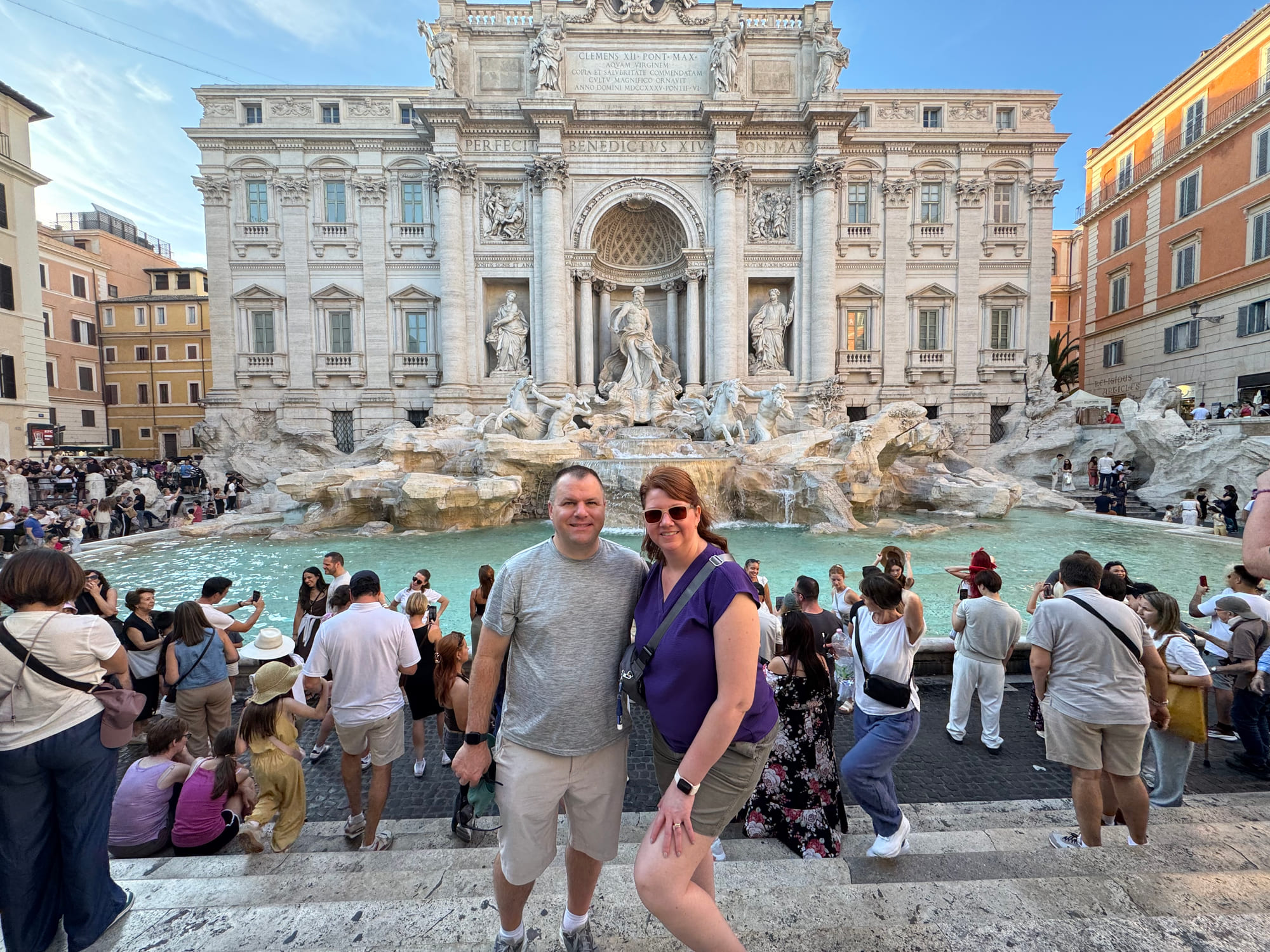 Angela and Brian standing together in front of the crowded Trevi Fountain