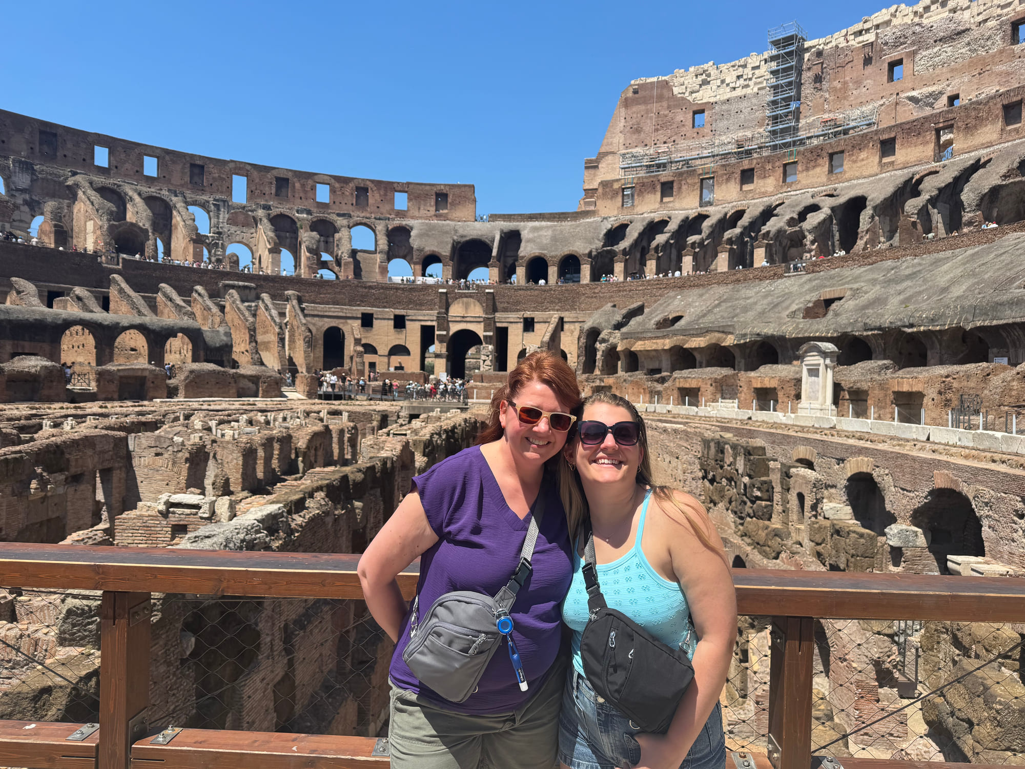 Angela and a family member smiling inside the Colosseum with the exposed underground structures behind them