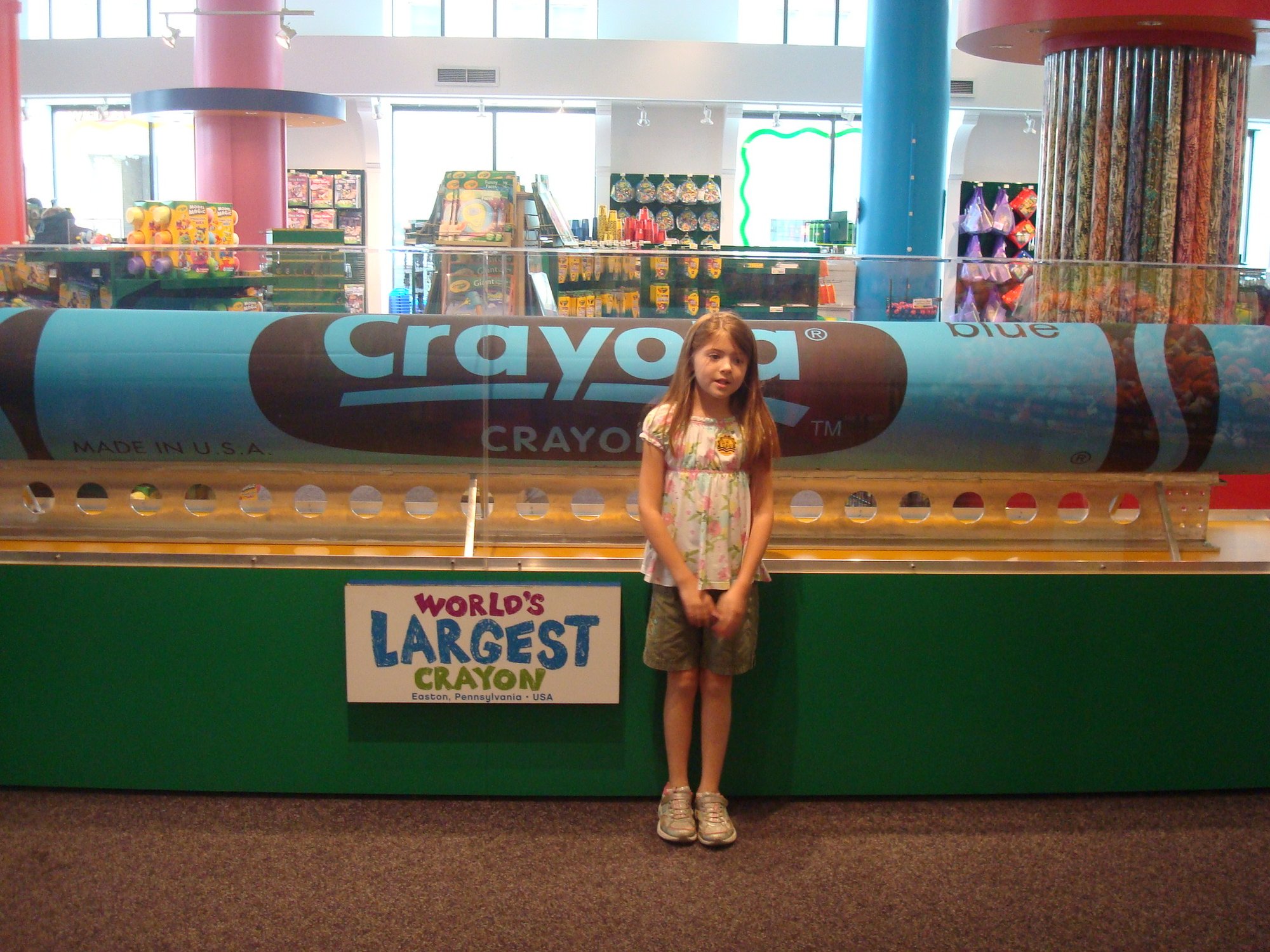 Angela’s daughter standing beside the World's Largest Crayon display in Easton
