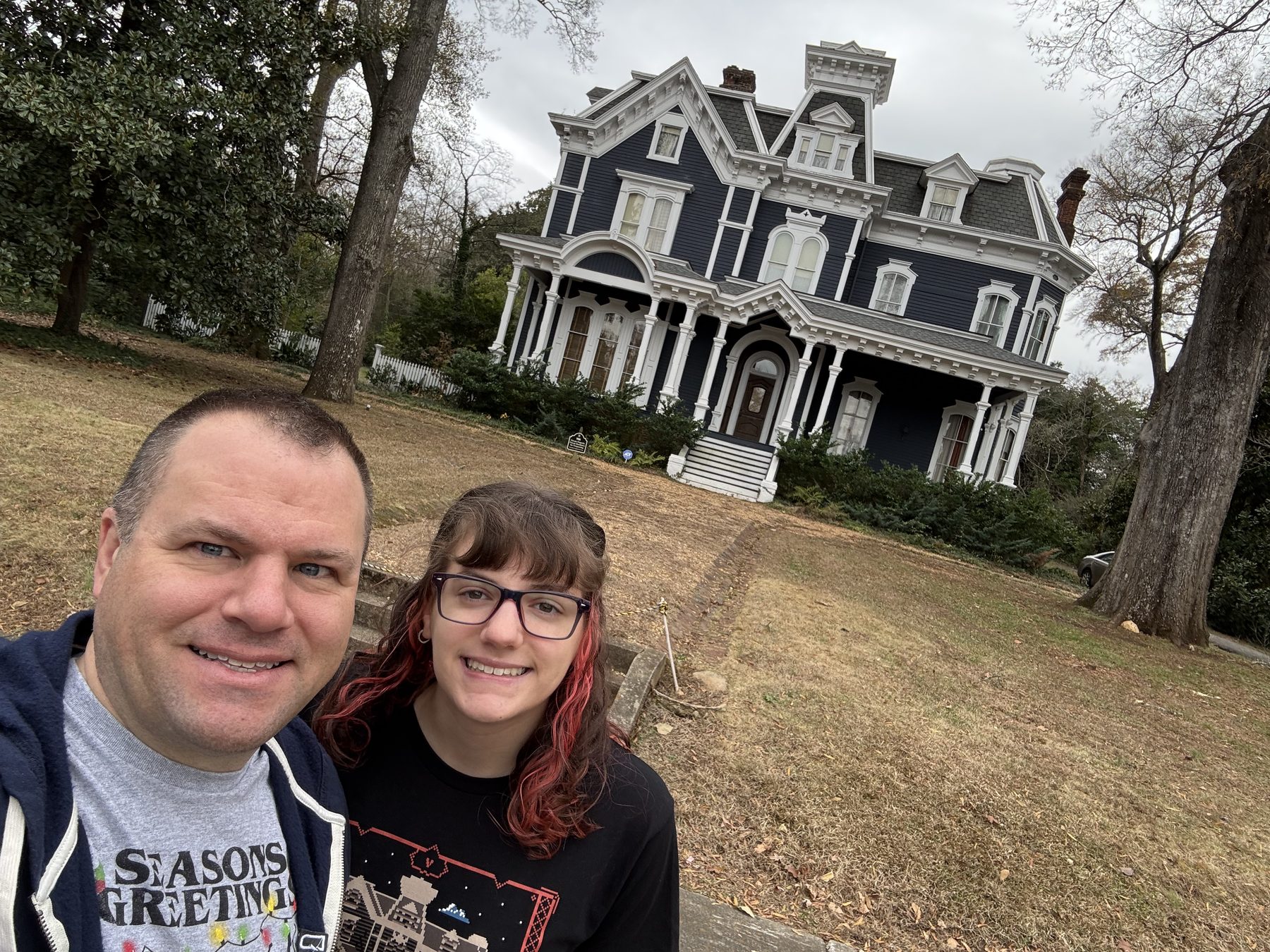 A father and daughter in front of the Victorian home used as the Creel House in Stranger Things
