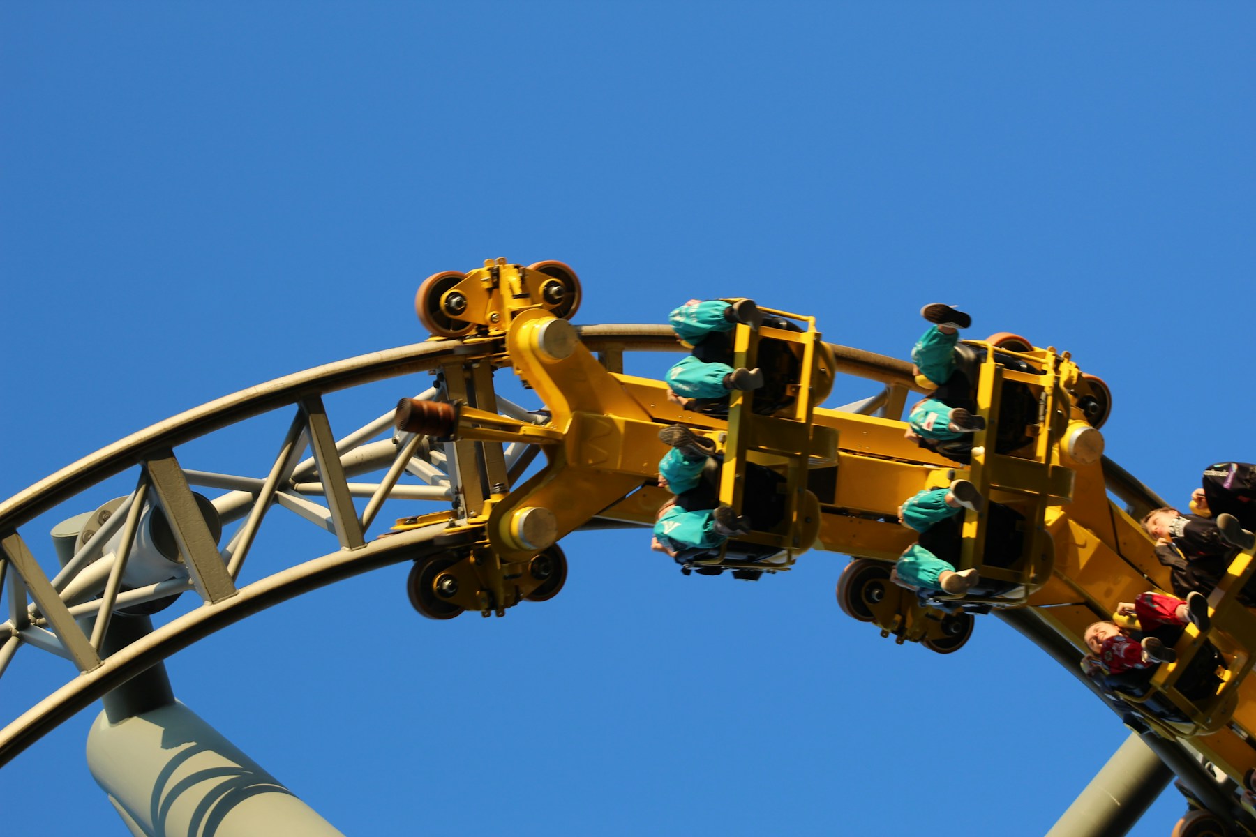 Guests riding a roller coaster through a steep curve