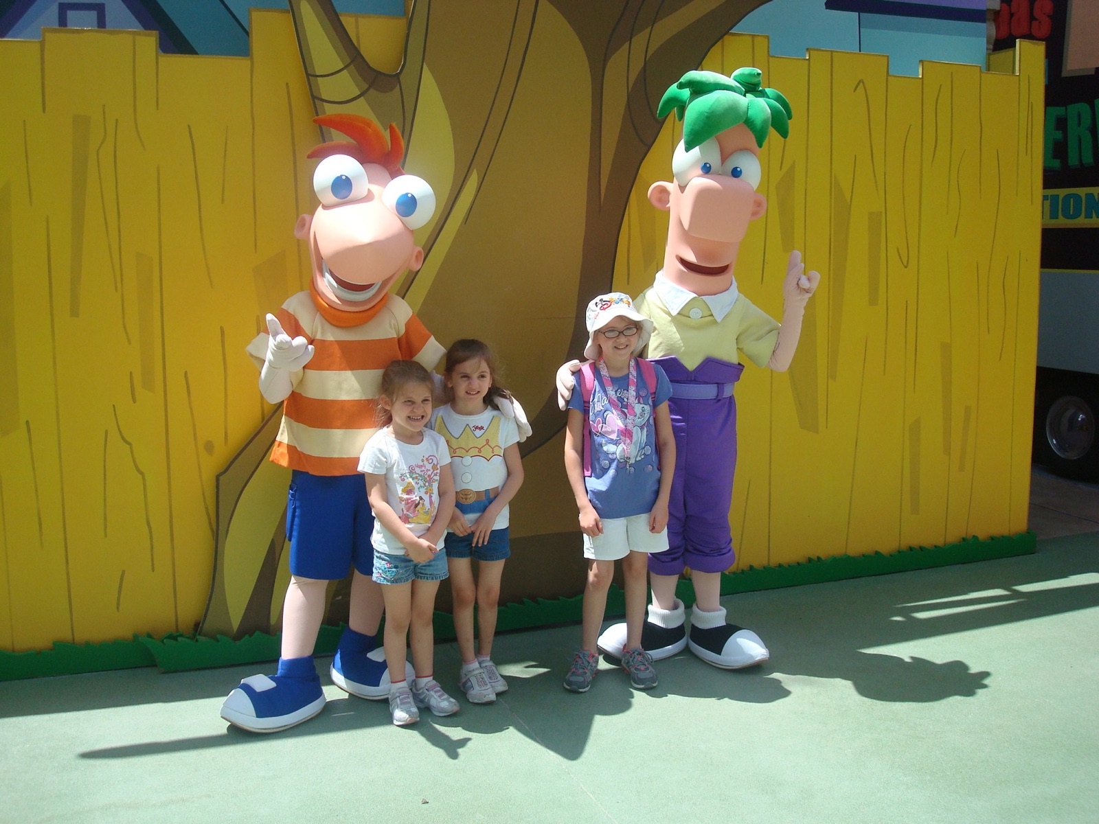 Angela’s three daughters posing with Phineas and Ferb at Walt Disney World when they were young