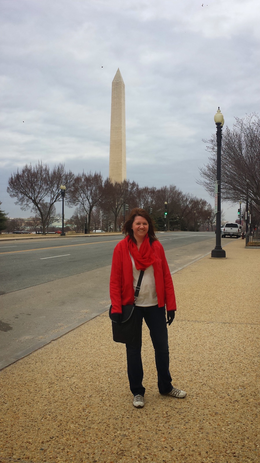 Angela standing near the National Mall with the Washington Monument behind her on a cloudy March day