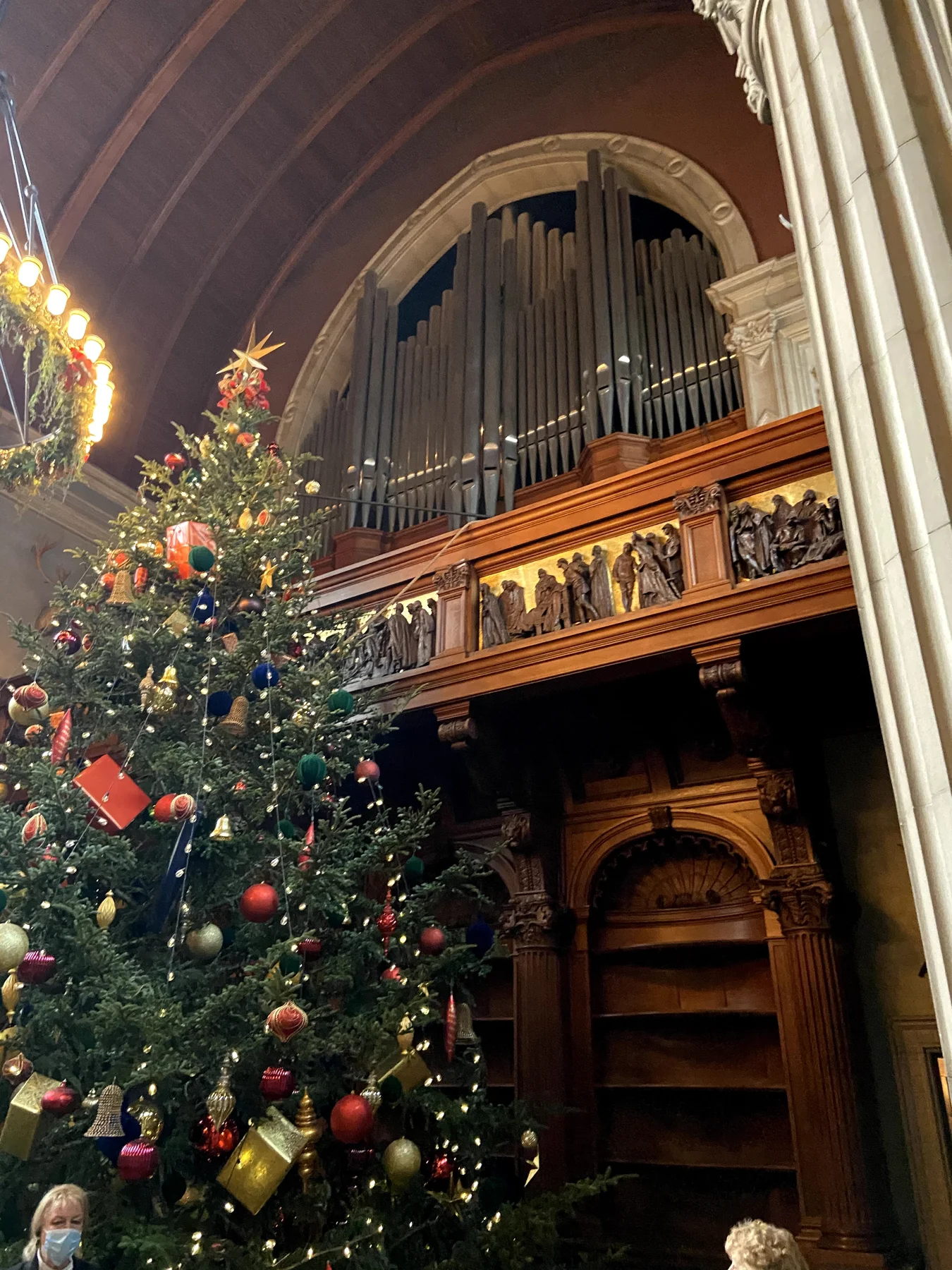 A tall decorated Christmas tree beneath the timber ceiling and organ pipes at Biltmore House