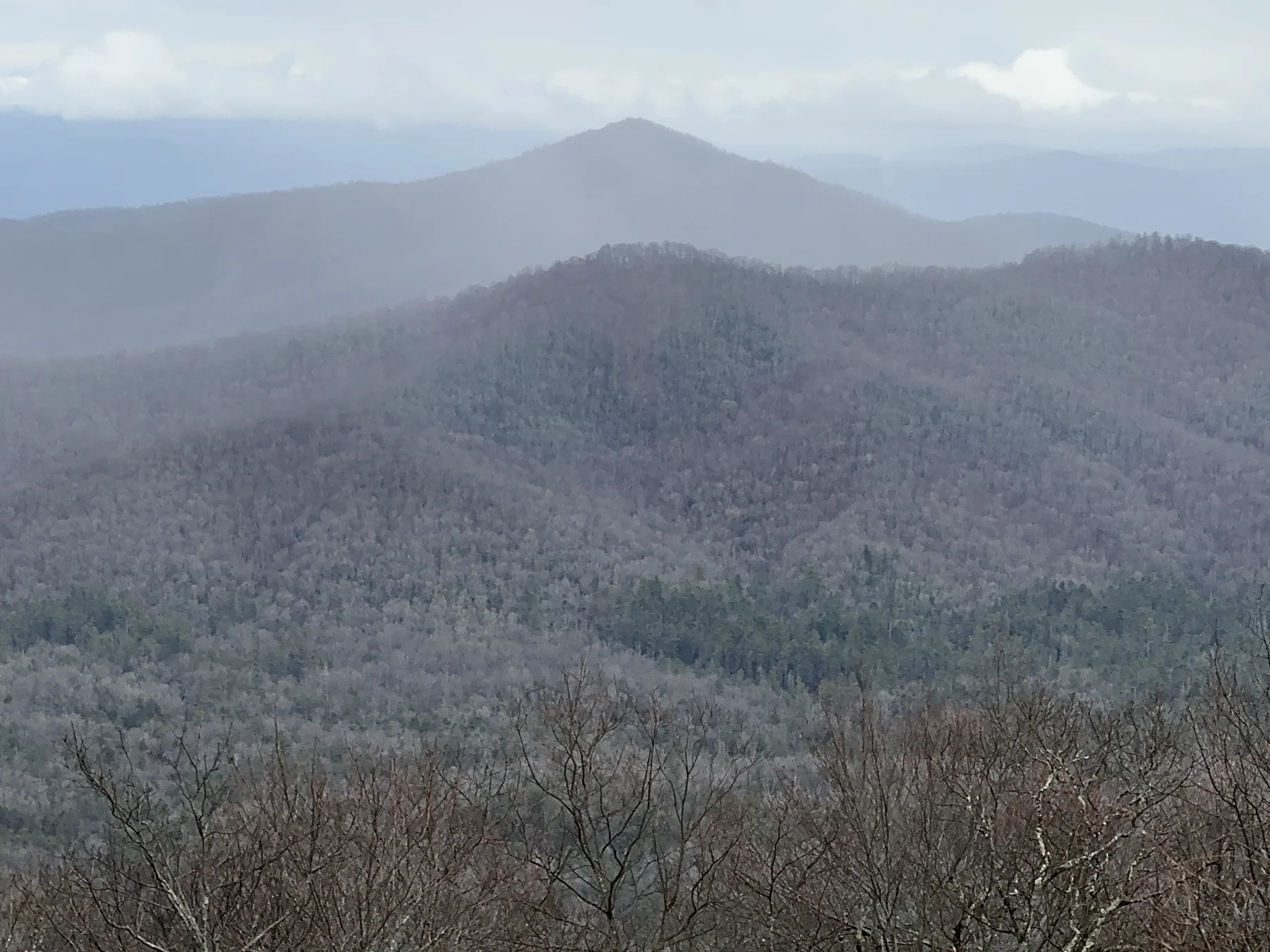 Layers of forested Blue Ridge Mountains beneath clouds, photographed from the Blue Ridge Parkway
