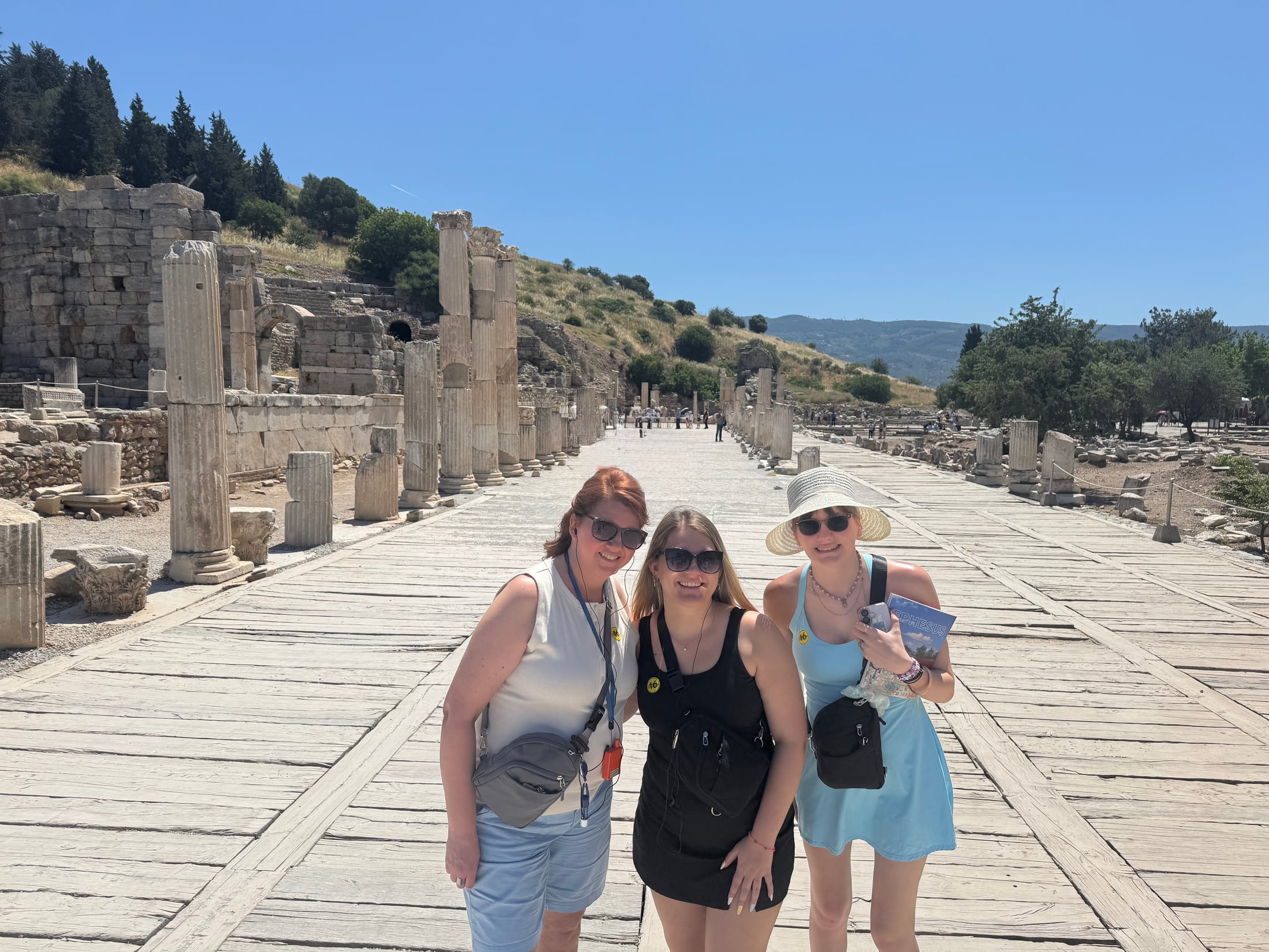 Angela and two family members standing on a broad marble-paved street among the ruins of Ephesus