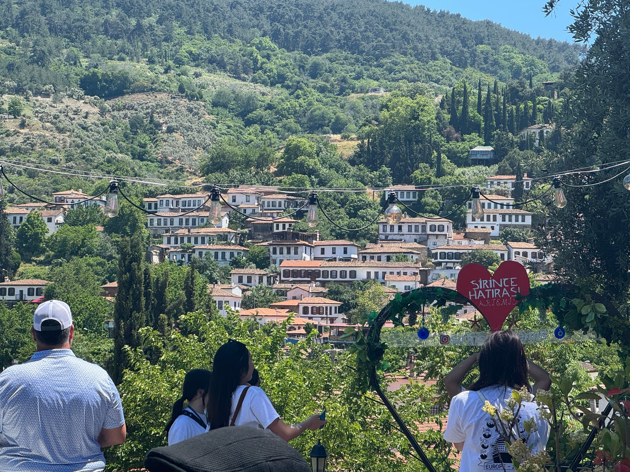 Traditional white houses with red tile roofs climbing the green hillside in Şirince