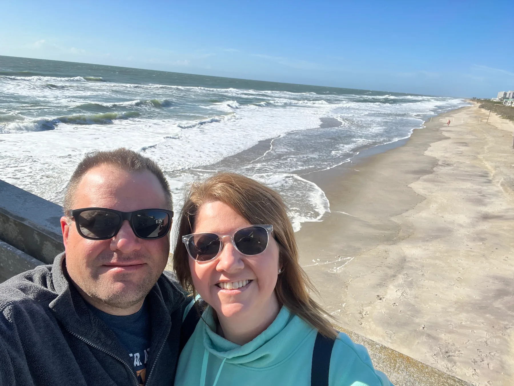 Angela and Brian at Wrightsville Beach with the Atlantic shoreline behind them